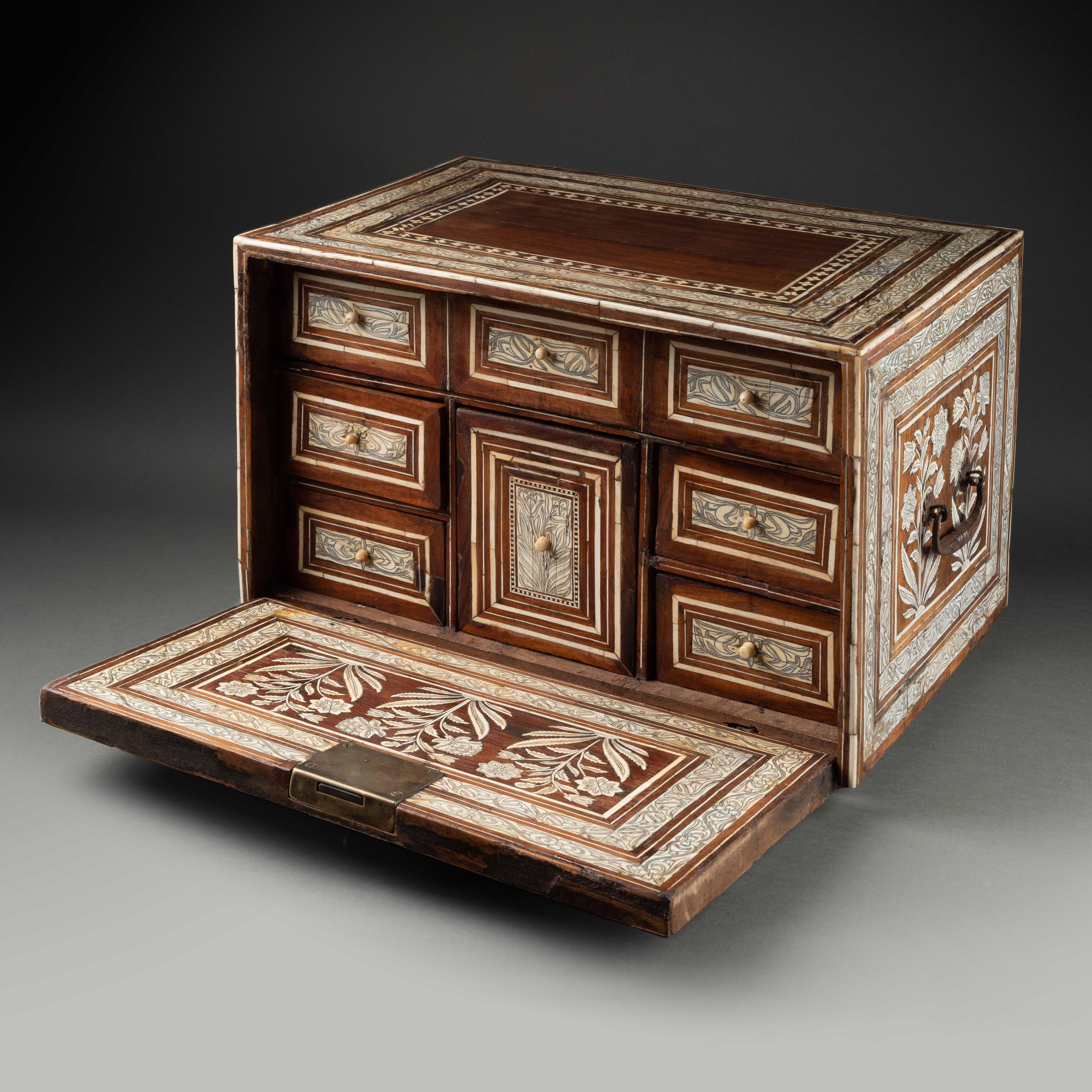 A Mughal ivory inlaid wood Cabinet
Noord-West Indie
17th century
27 x 40,2 x 30 cm
Cites number : 2023/BE00124/CE


Of rectangular form with fall-front opening profusely decorated in ivory inlay; sides with rectangular panels containing large