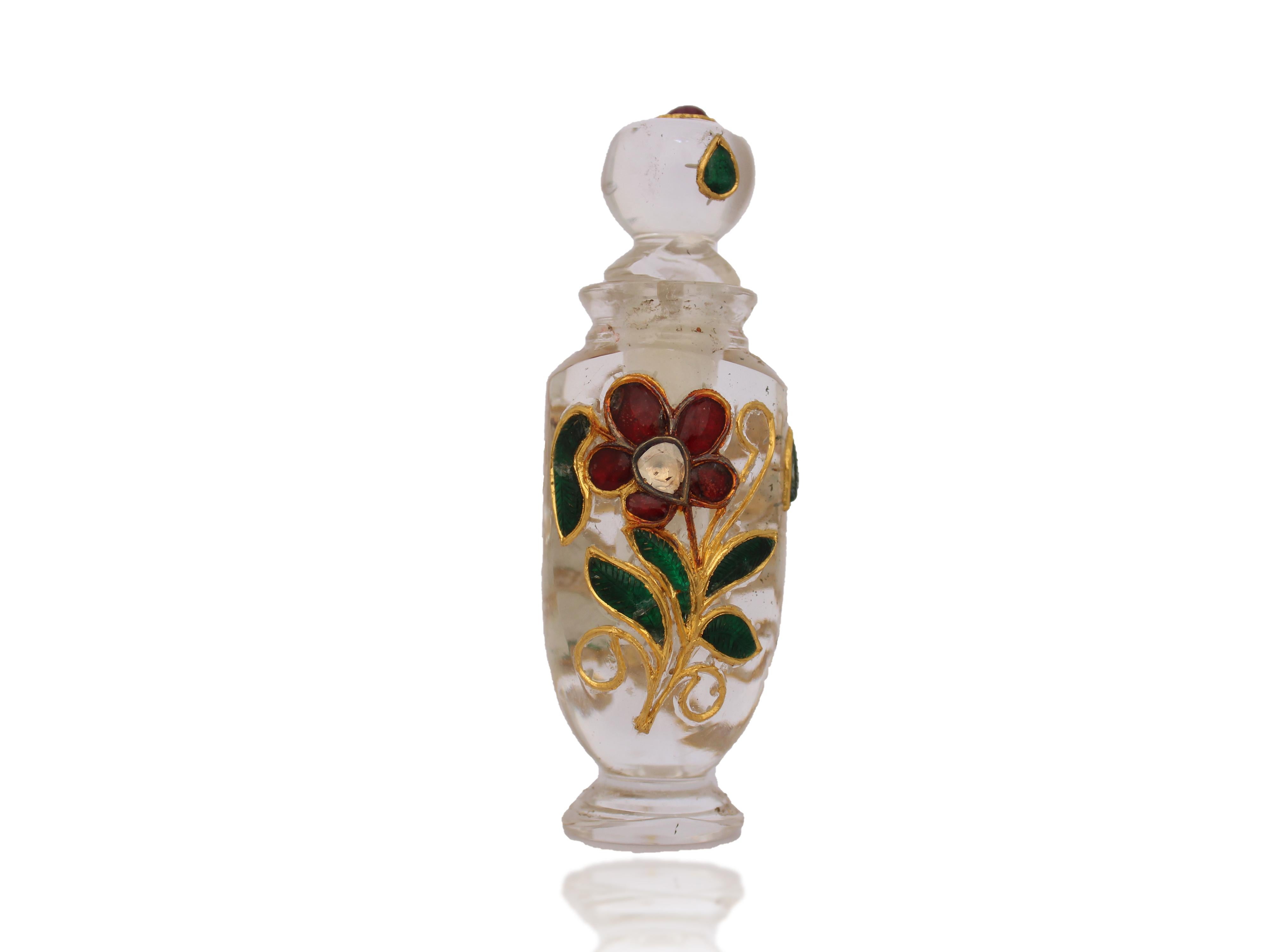 A Mughal style perfume bottle (Itradani), Each side of the bottle is inlaid with 24K gold encrusted with carved petal in green and flower petals in rubies and diamonds, the stopper at the is rounded and attached itself to the bottle in a firm