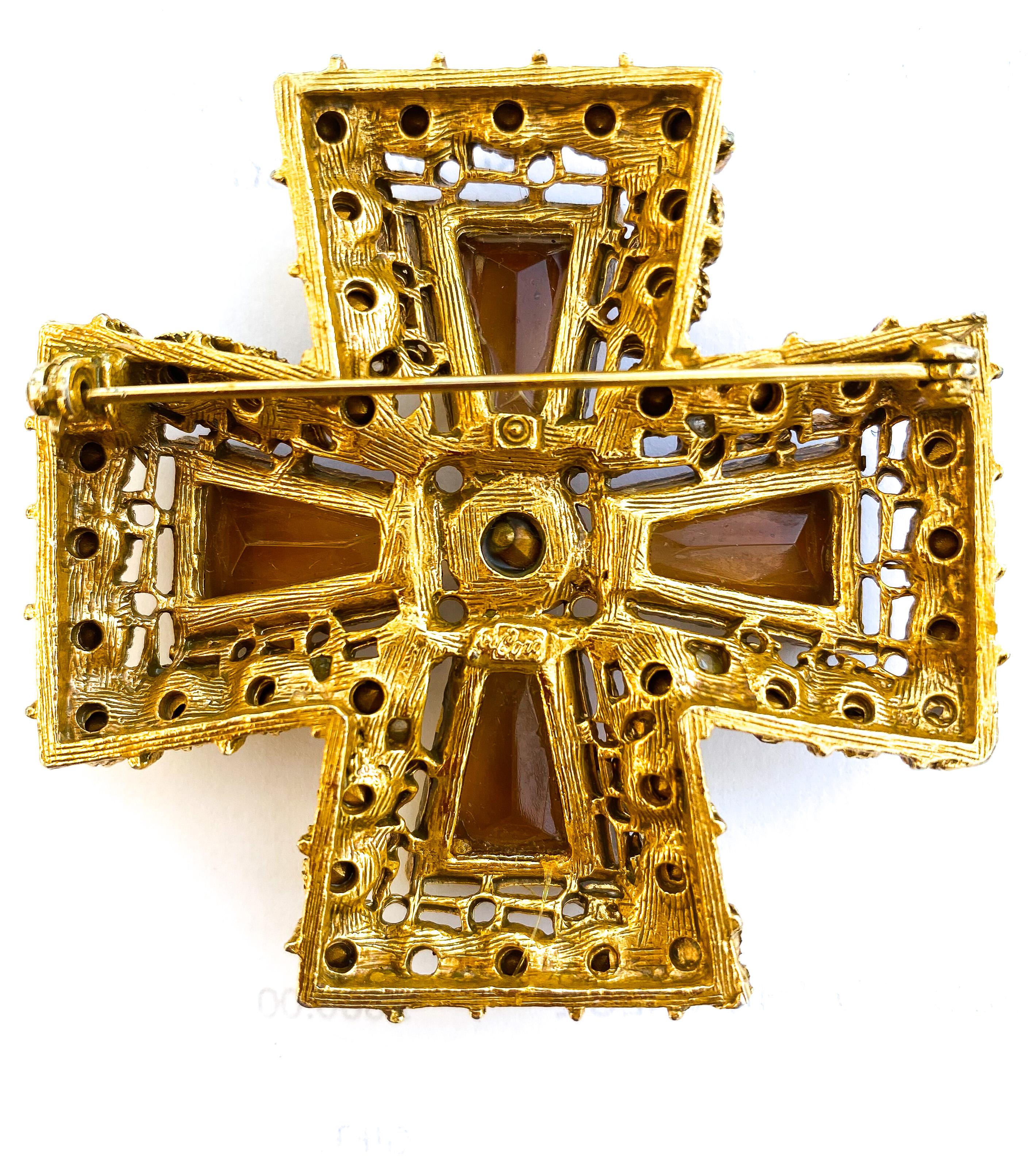 A striking and highly decorative brooch , in the form of a Maltese Cross, designed and manufactured by Coro, in the 1950s. Composed of four large faceted and tapered topaz glass stones, each is surrounded by citrine, topaz and soft grey pastes, with