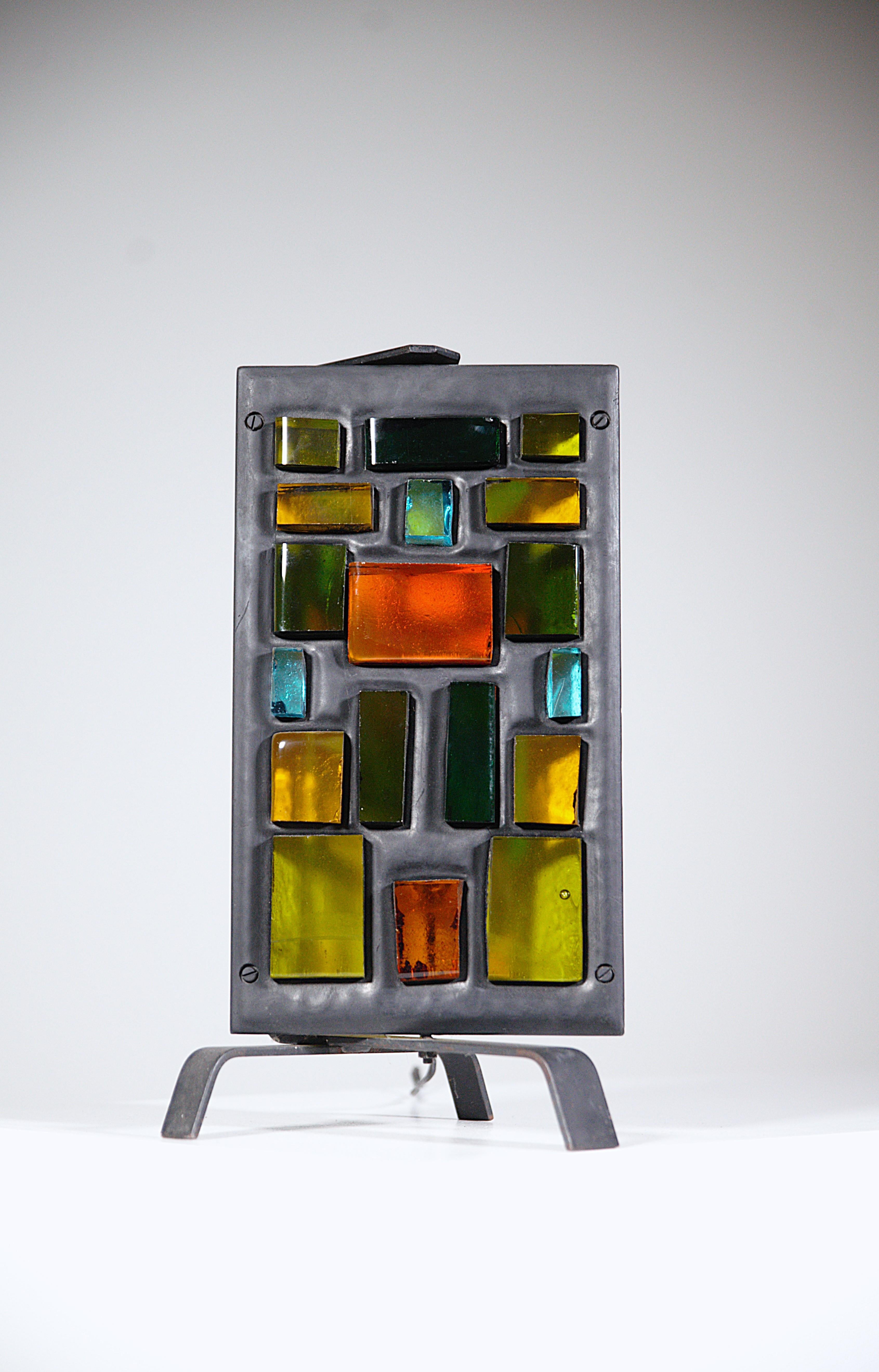 Lampada brutalista di Jean Simon Labret Francia anni '70
 
Pezzo di vetro colorato tagliato e metallo.

Orientabile.

In buone condizioni.

