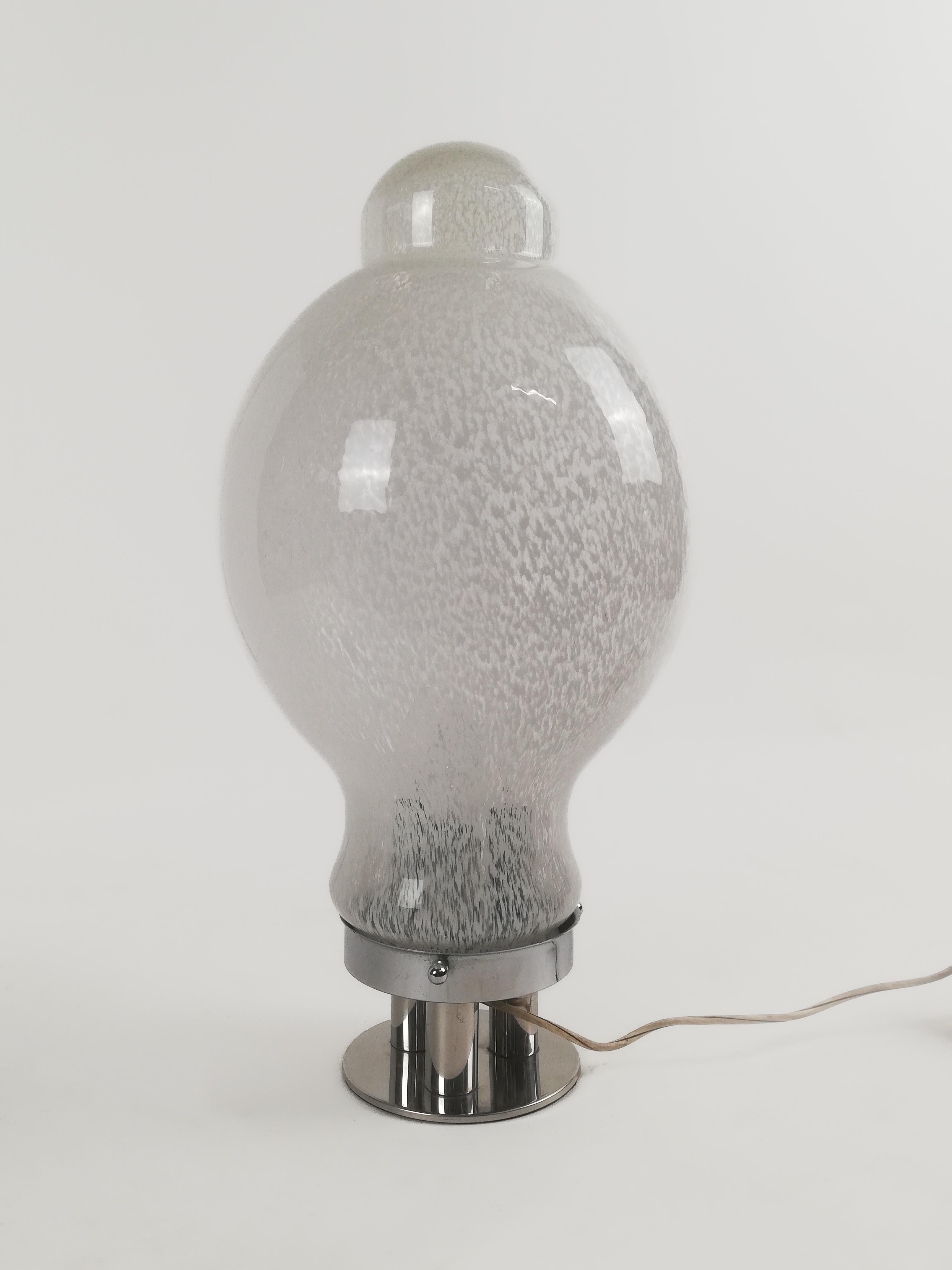 A Splendid giant Italian table lamp made in Murano blown glass and chromed metal.
Datable to around the 1970s, the lamp recalls for design and materials the productions of the historic Venetian company 