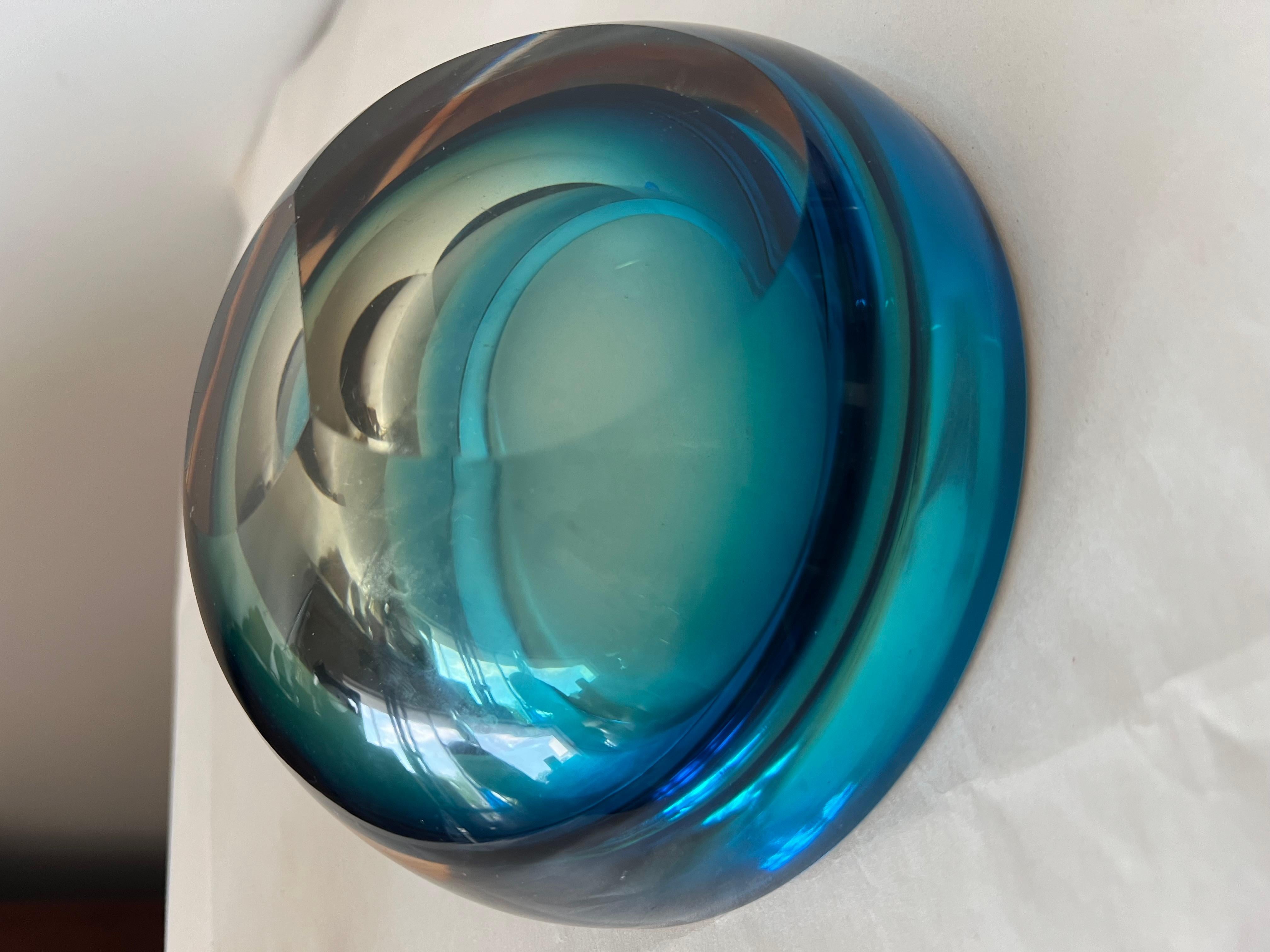 Una interesante pieza de vidrio pesado realizada probablemente por Flavio Poli, Murano. Círculos concéntricos de varios colores. Base pulida en dos puntos angulares que permiten colocarla en ángulo u horizontal. 