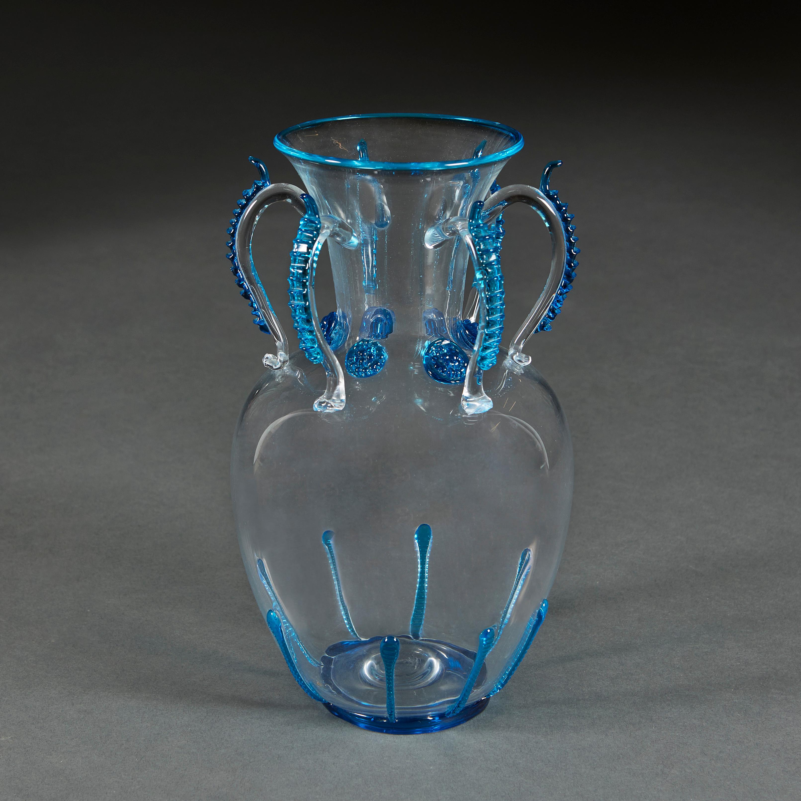 Italy, circa 1960

A Murano glass vase with six loop handles to the neck, with blue glass applique flowers to the neck and drips to the base.

Measures: Height 29.00cm
Total diameter 16.00cm
Diameter of base 9.00cm.