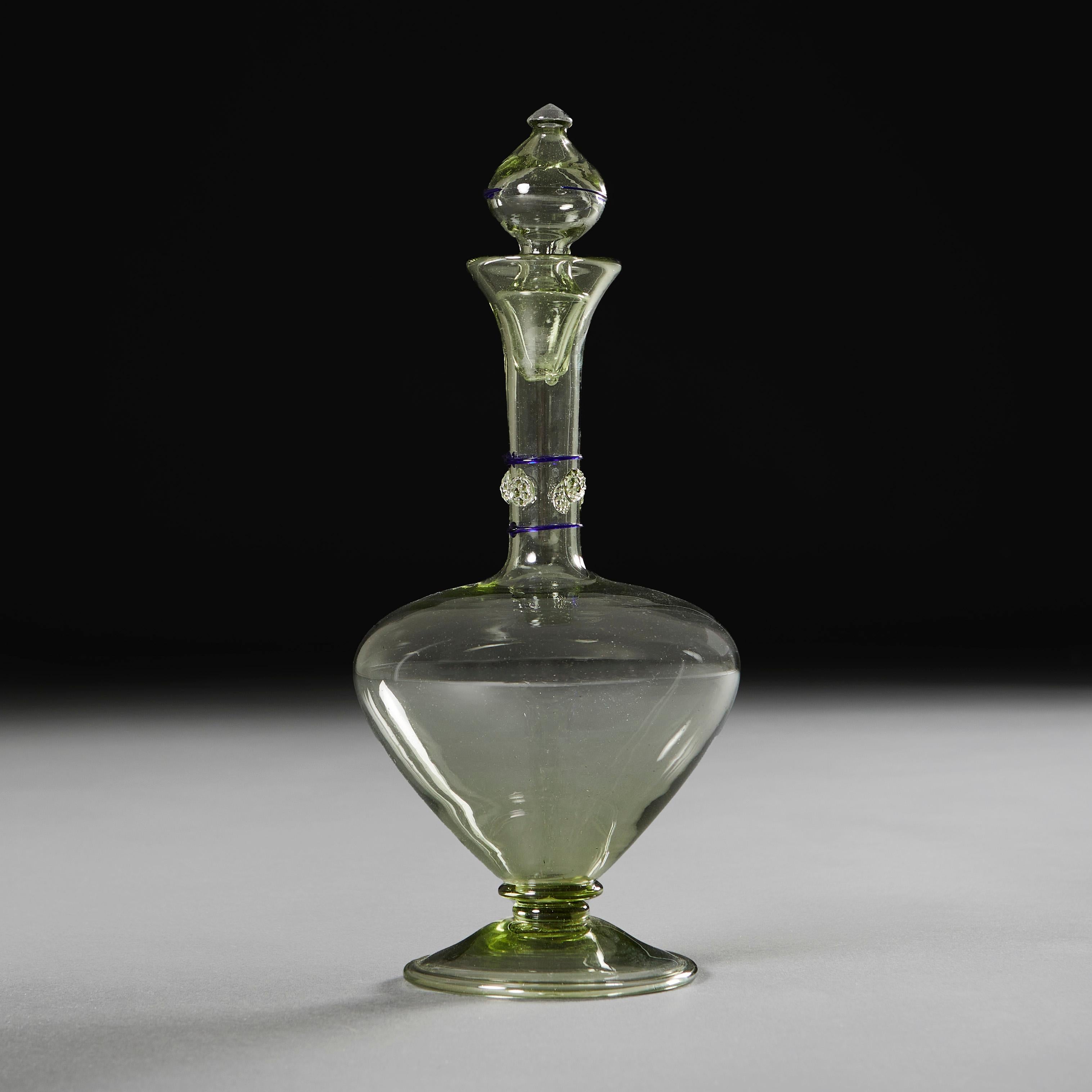 Italy, circa 1940

An early twentieth century Murano green glass decanter, with applied decoration to the neck and stopper, supported on a circular base.

Height   32.00cm
Diameter   11.00cm