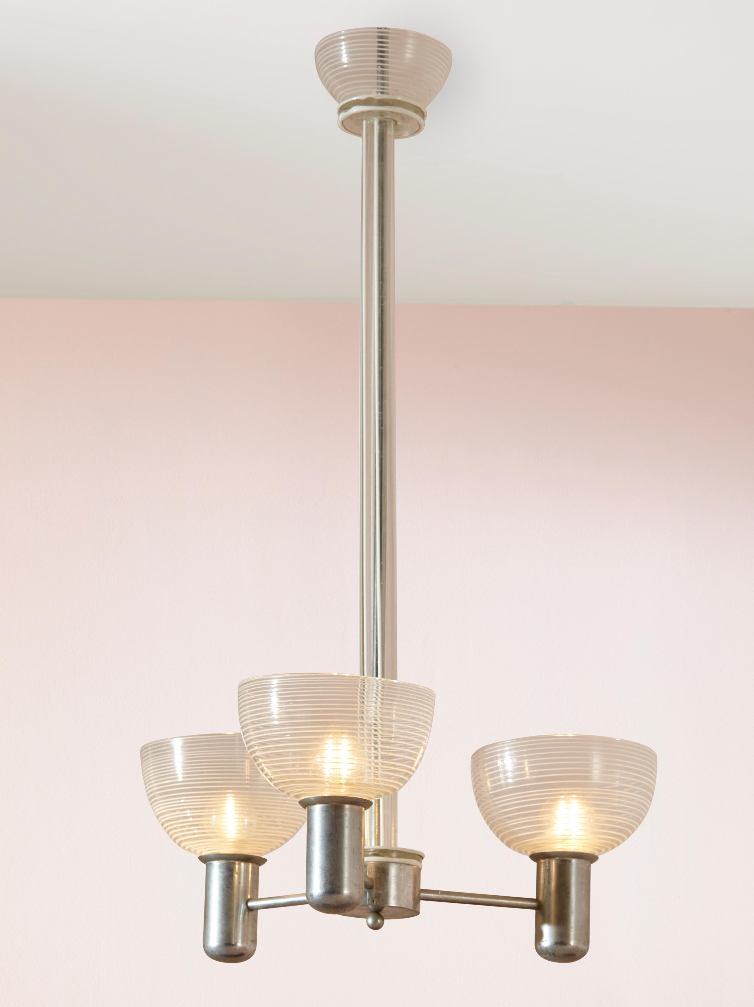 A rare and beautiful rationalist chandelier from the 1930s, crafted with exquisite Murano glass using the filigrana and lattimo techniques. With its metal frame and three arms, this chandelier effortlessly combines functionality and aesthetic