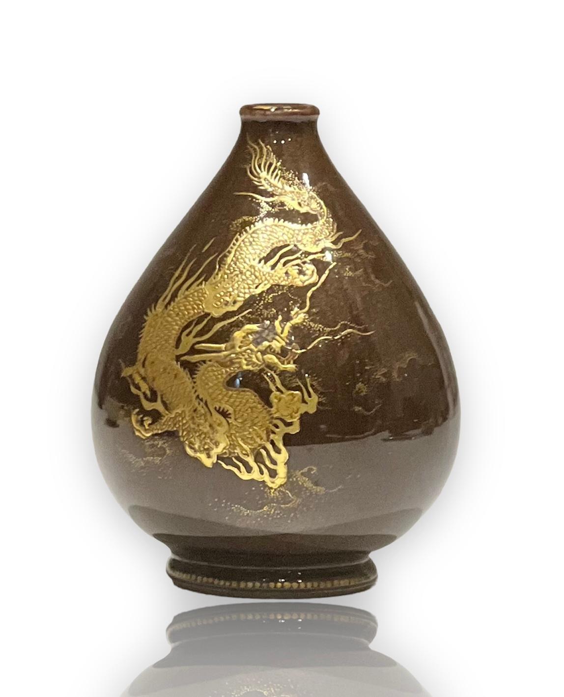 A museum quality satsuma miniature pear single-stem vase.
By Kinkozan, Meiji era (1868-1912), late 19th century.
Decorated in predominantly in gold enamels with a writhing three-clawed dragon grasping a tama (jewel) on a brown flambé-style ground;