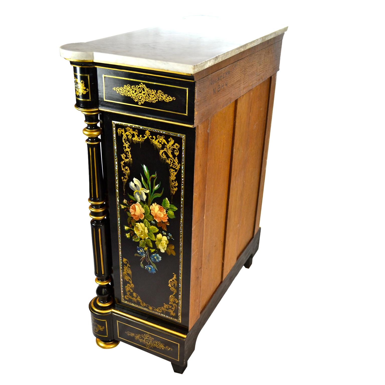 A Napoleon III ebonized cabinet with front and sides decorated with hand painted floral medallions. The cabinet has turned columns to each side with gilded decoration, and is further decorated with intricately painted gilding, a single lockable door