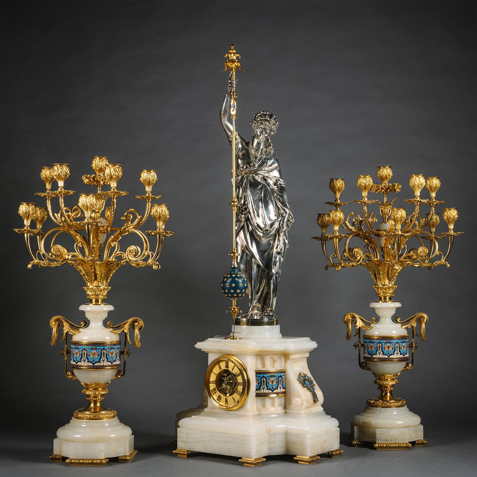 Un Reloj Napoleón III de Bronce Dorado y Plateado, Ónice y Esmalte Champlevé Figural de Tres Piezas. De Eugène Cornu para la Société des Marbres Onyx d'Algerie, la figura es un molde de un modelo de Albert-Ernest Carrier-Belleuse (1824-1887), el