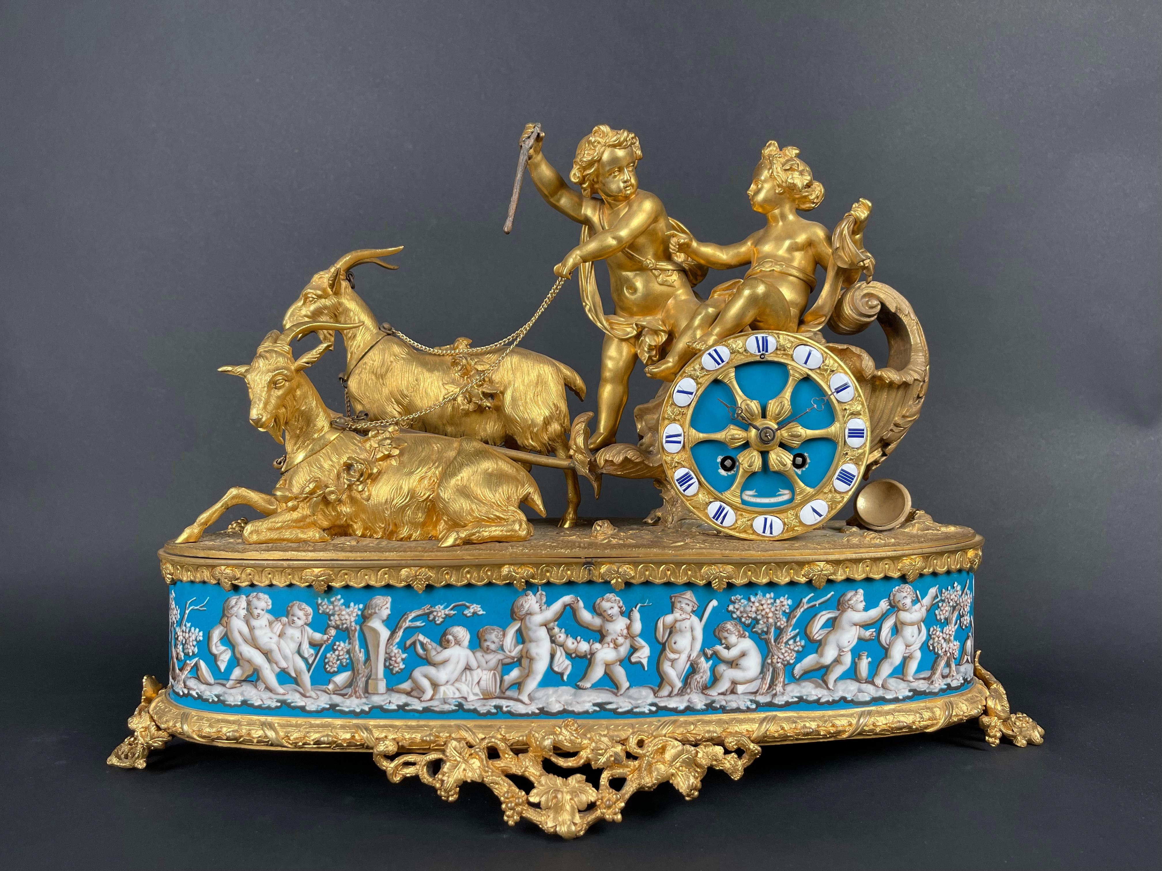 A Napoleon III gilt-bronze and porcelain clock By Levy Freres, France, 19th Century. 

The clock surmounted by two putti on a goat-driven chariot mounted on a porcelain bace.

21
