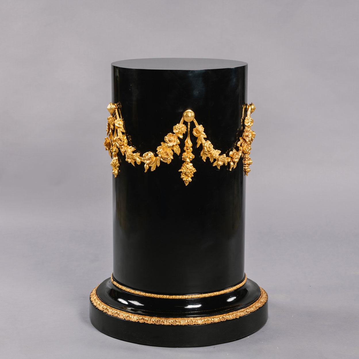 A Napoleon III gilt-bronze mounted Ebonised pedestal.

The circular top above a guilloche band and a cylindrical body set with floral garlands, raised on a circular spreading base with stiff leaf bands. 

France, Circa 1870.
 
