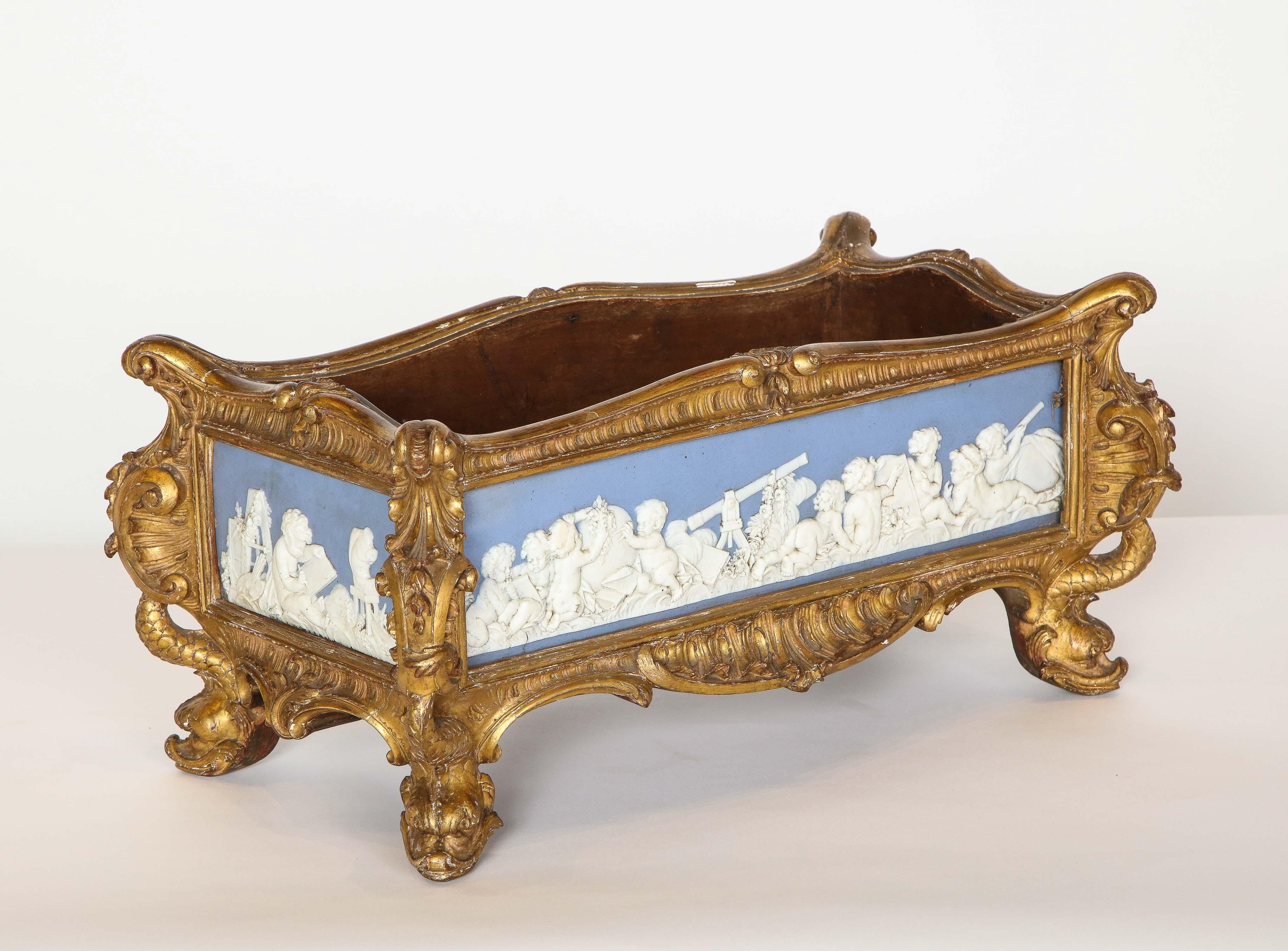 A Napoleon III Giltwood and Jasperware Wedgewood Centerpiece Jardinière, circa 1870.

Very fine quality, with craved dragon feet, and rococo scrolls throughout. Mounted with four extremely fine quality Wedgewood / jasperware plaques of