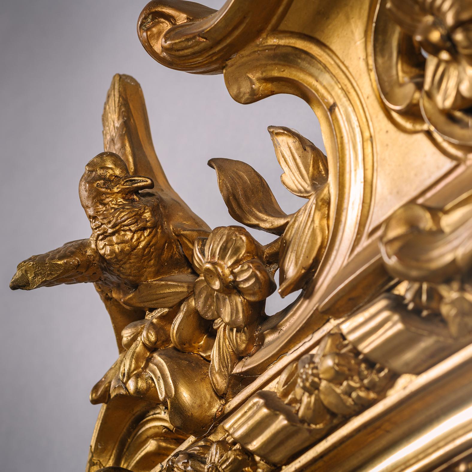 Ein Napoleon III Giltwood und Gilt-Gesso Overmantel Spiegel. Frankreich, ca. 1860

Dieser feine und große Übermantelspiegel ist im Louis XV-Stil gestaltet und reichlich mit Attributen des Frühlings verziert. In der Mitte des gewölbten Giebels