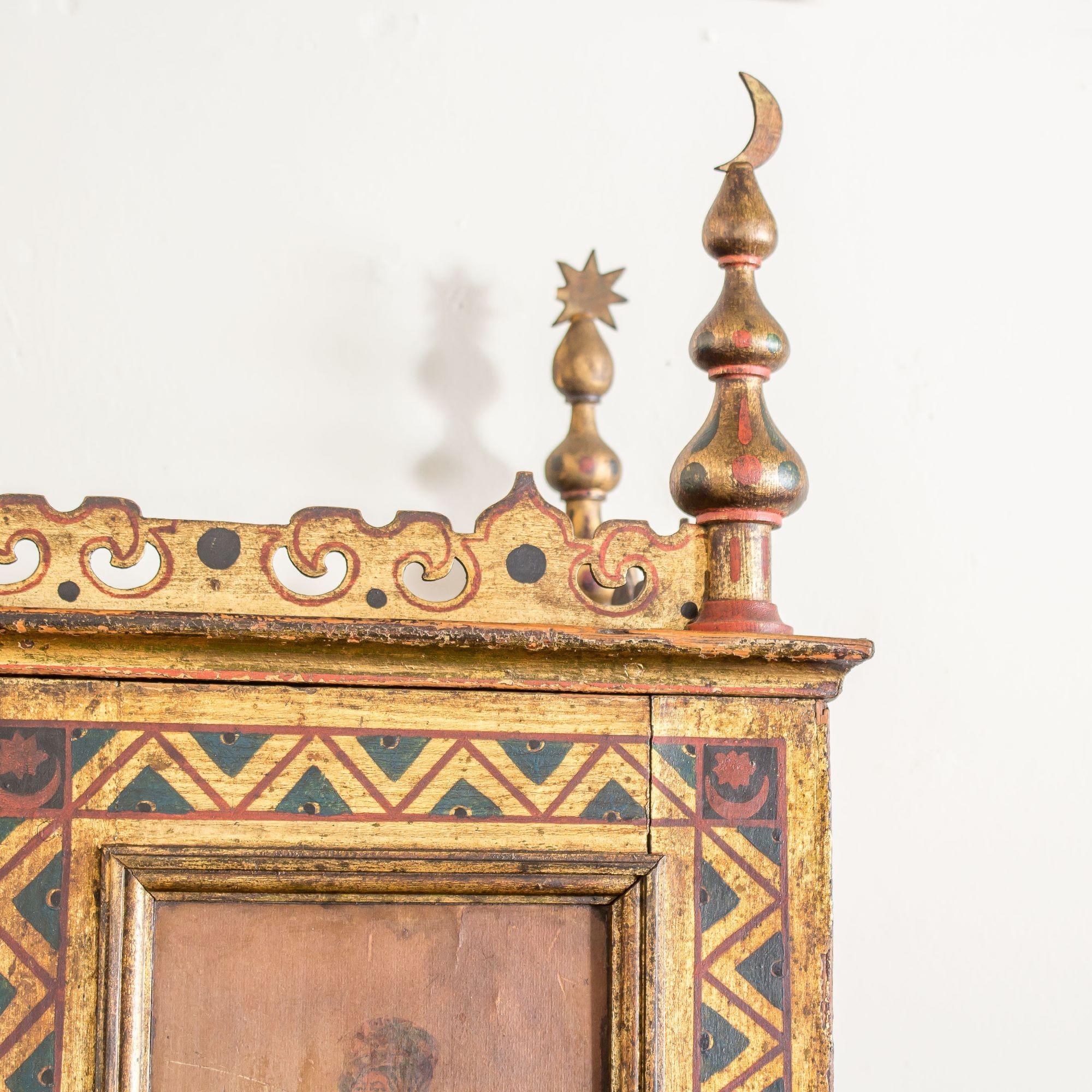 The two doors decorated with painted and gilt zig-zag borders surrounding four Russian figures enclosing 24 drawers. Each top corner with Moorish finials complete with stars and moons joined by a pierced Moorish apron.

With pencil writing and an