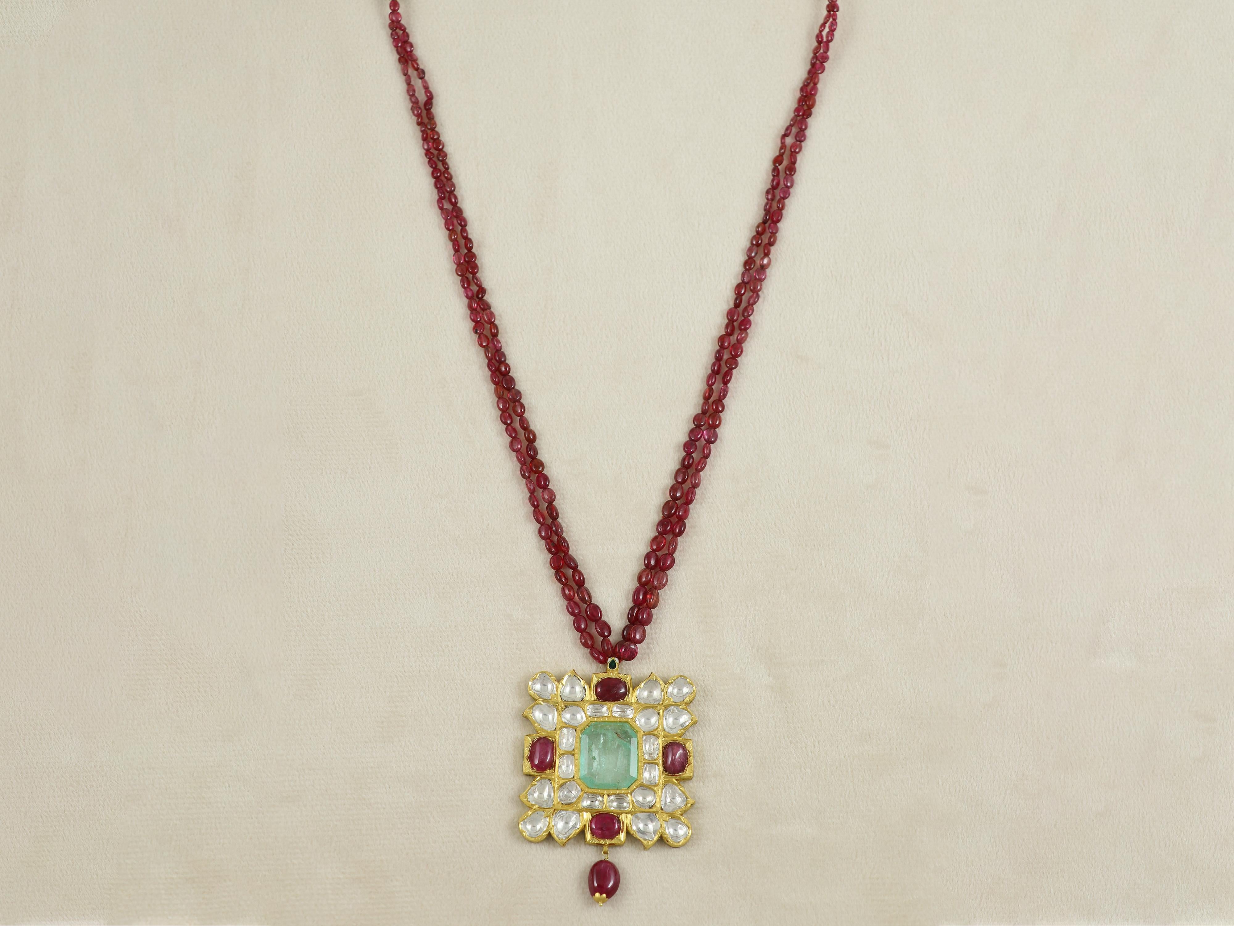 Set with a natural non resin 11.50ct Colombian emerald at centre set in kundan setting with open back, this pendant is done in 22.5K gold purity. The pendant is testament to Indian heritage and craftsmanship with gold purity giving its affect in the