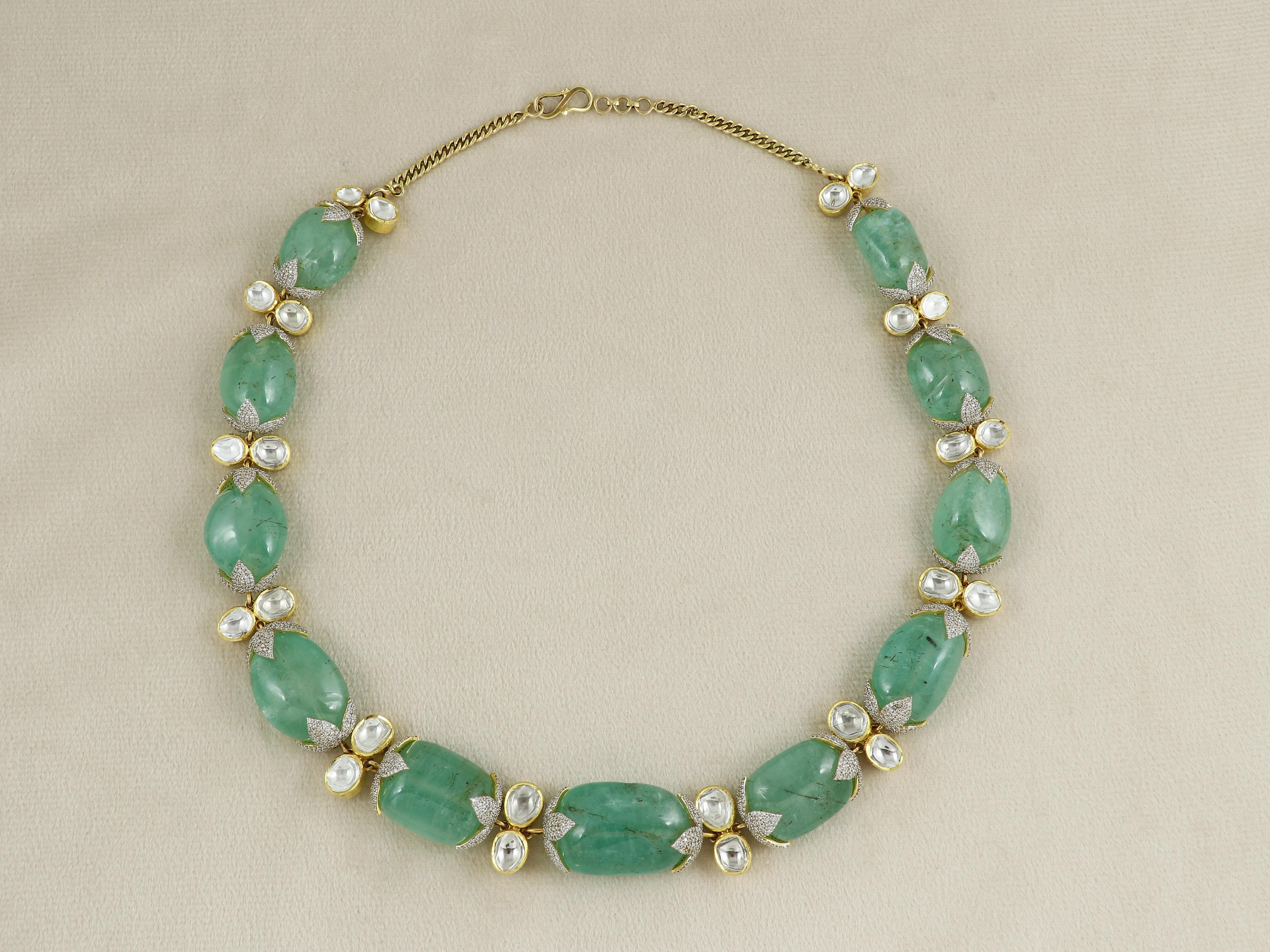 Made from a collection of 11 large size natural emerald tumbles from russian origin this emerald necklace has been handcrafted in 18K yellow gold, and has been studded with 10cts of natural diamonds.

Each tumble has been specially capped with white