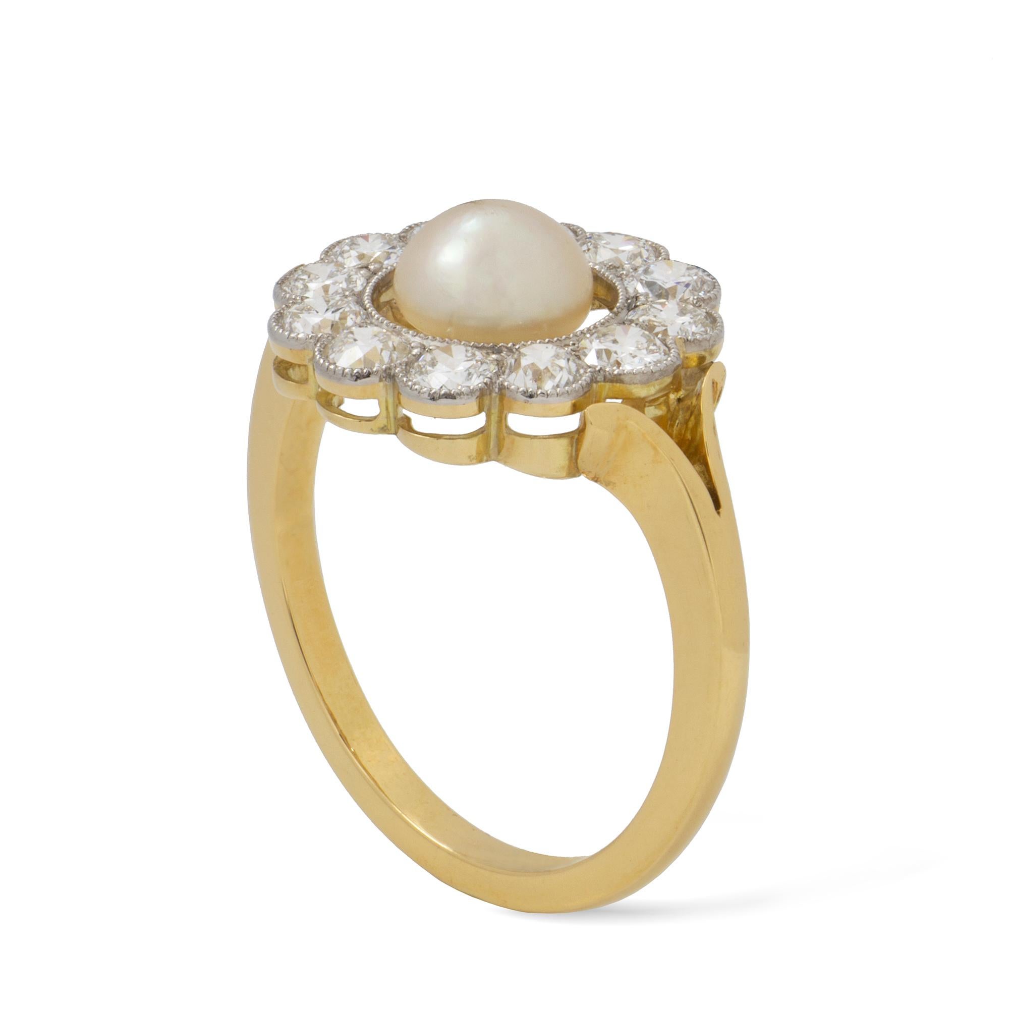 A natural pearl and diamond cluster ring, the natural pearl surrounded by a daylight and twelve transition-cut diamonds, estimated to weigh a total of 1.20 carats millegrain-set in platinum to yellow gold mount, with gold split-design shoulders,