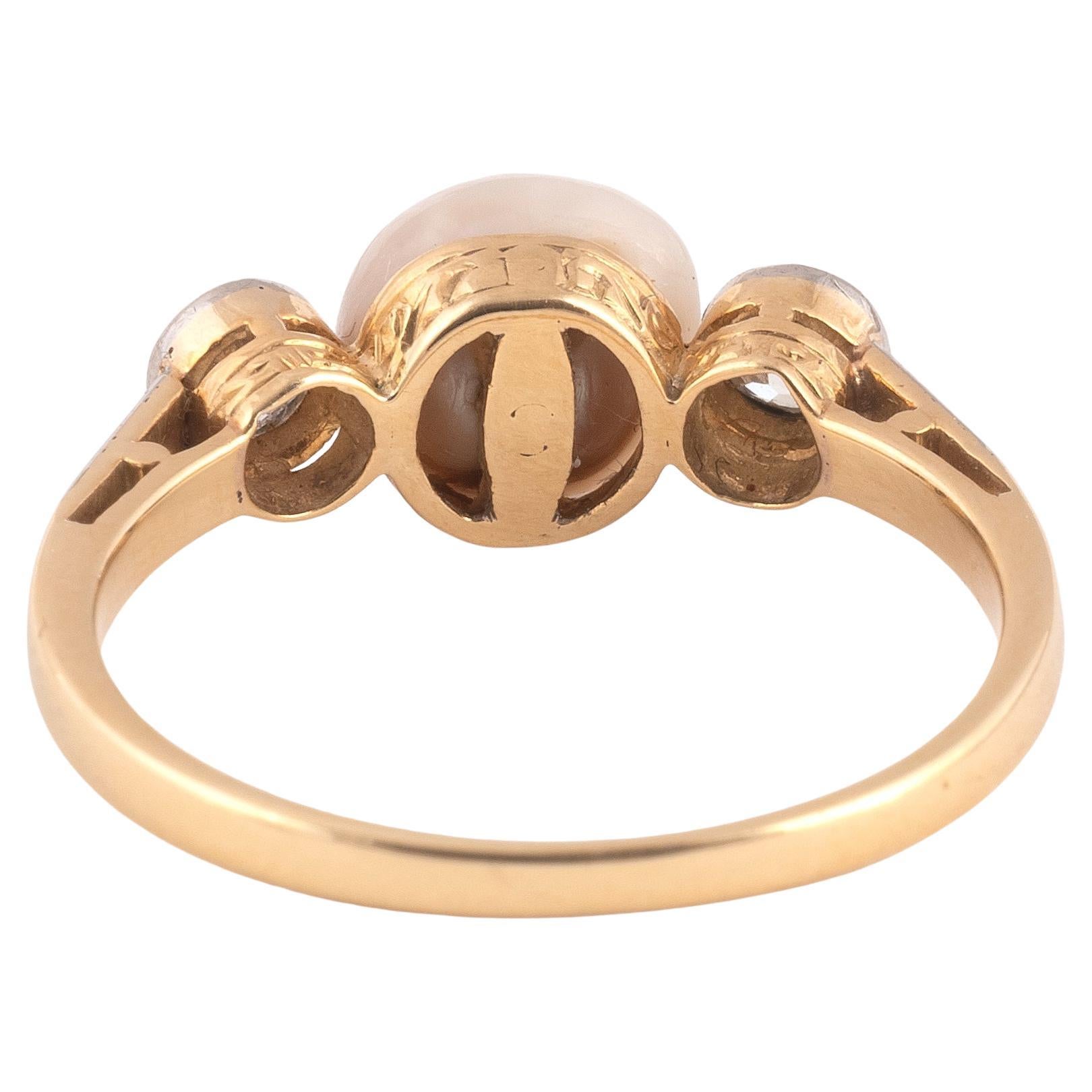 The 7.5mm natural pearl between two old brilliant-cut diamonds, diamonds approx. 0.50cts total.
Mounted in platinum and 18kt yellow gold.
Ring size approx 8
Weight: 2.9gr.

