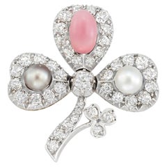 A natural pearl, queen conch pearl and diamond clover brooch