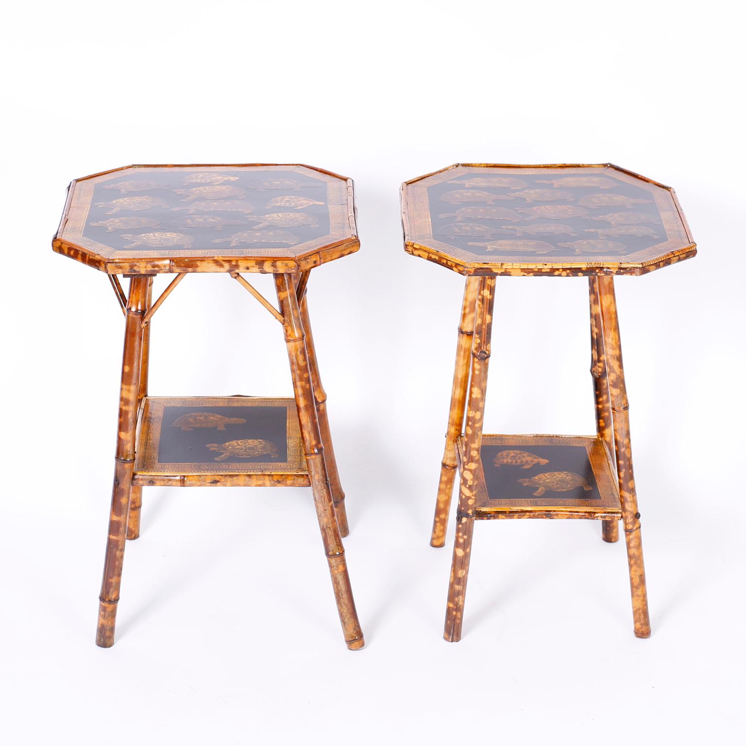 A near pair of English bamboo tables, each with two tiers having decoupage turtles on a black background.