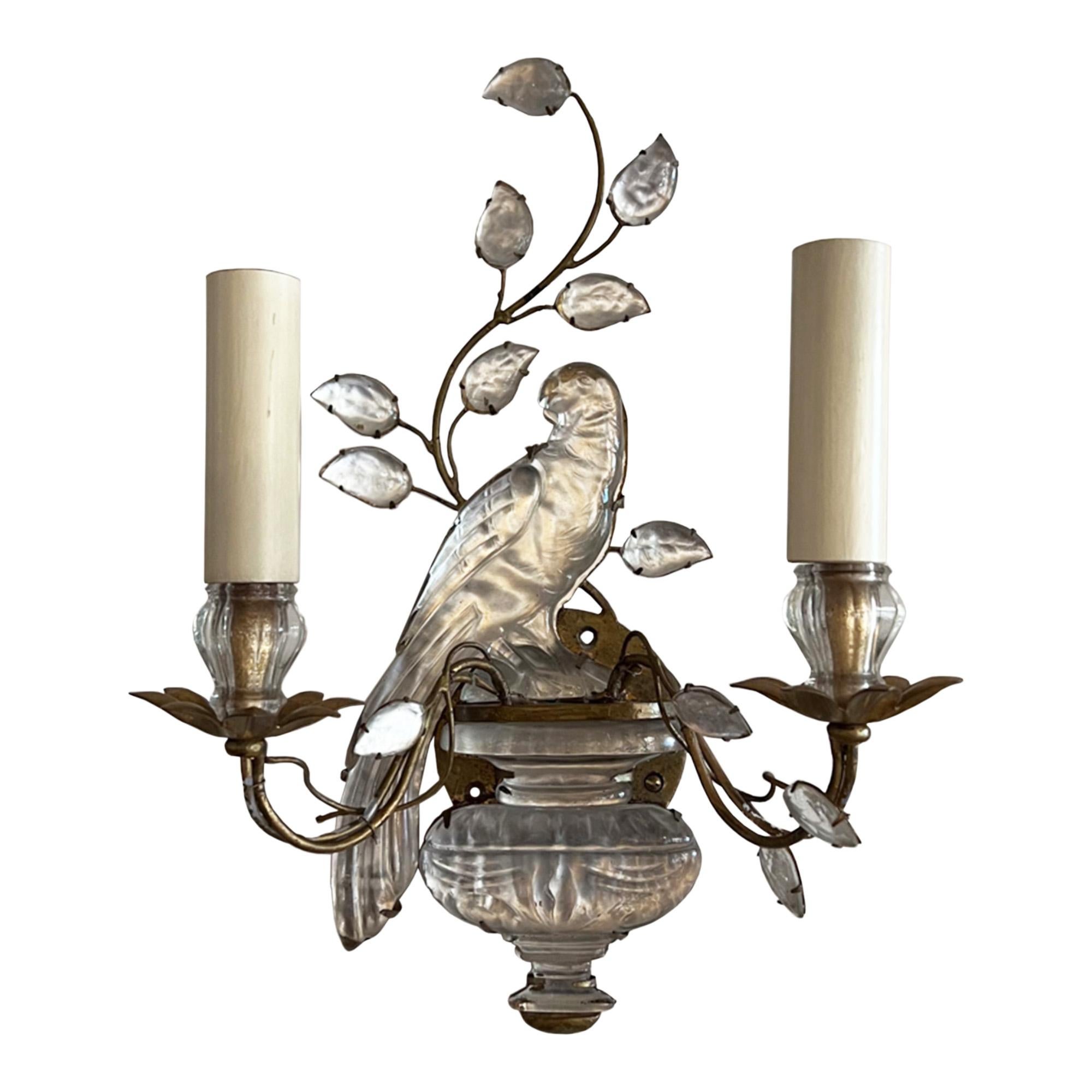 This is a near pair of Maison Baguès wall sconces with their iconic parrot and urn design. 

The parrots are traditionally paired as they are here - one facing left, while the other faces right.

However, we would like to point out the slight