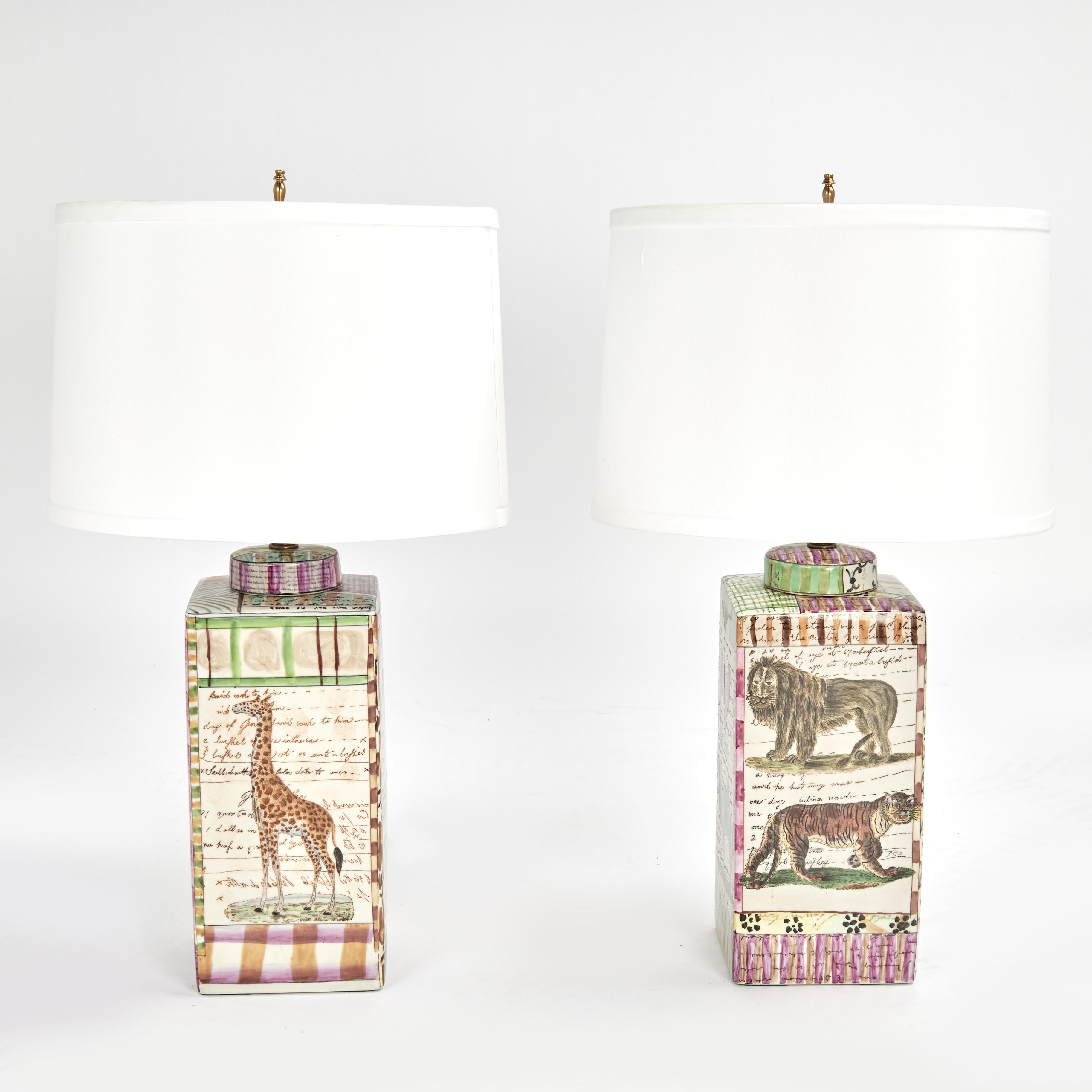 Transporting near pair of table lamps hand decorated with African animals and related stories on a lidded jar form. Signed on the bottoms John Derian New York.