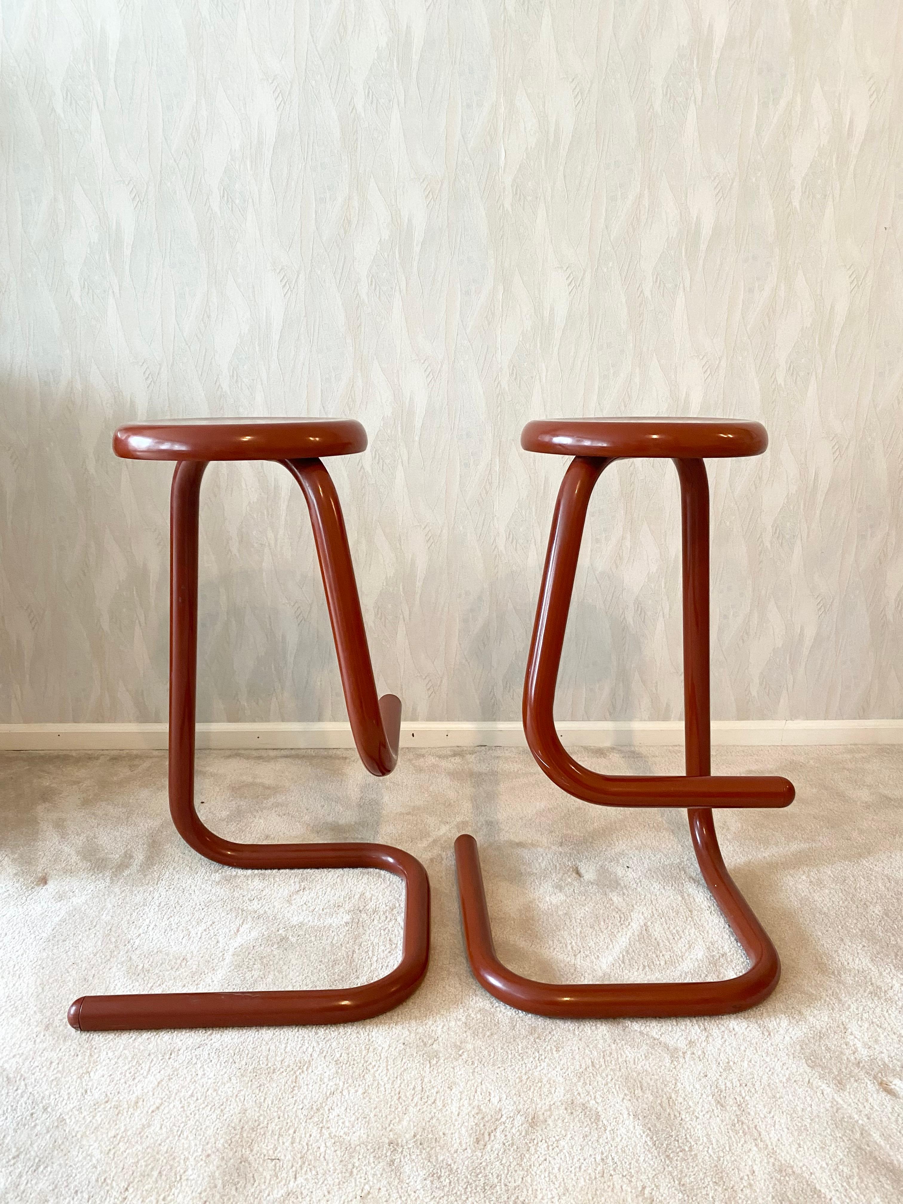 A rare set of shiny red k700 Paperclip stools by Kinetics, Canada. This pair had one owner for 37 years, and has been carefully looked after. The Paperclip stool is one of those ideal pieces of design, one singular line creates the structure. The
