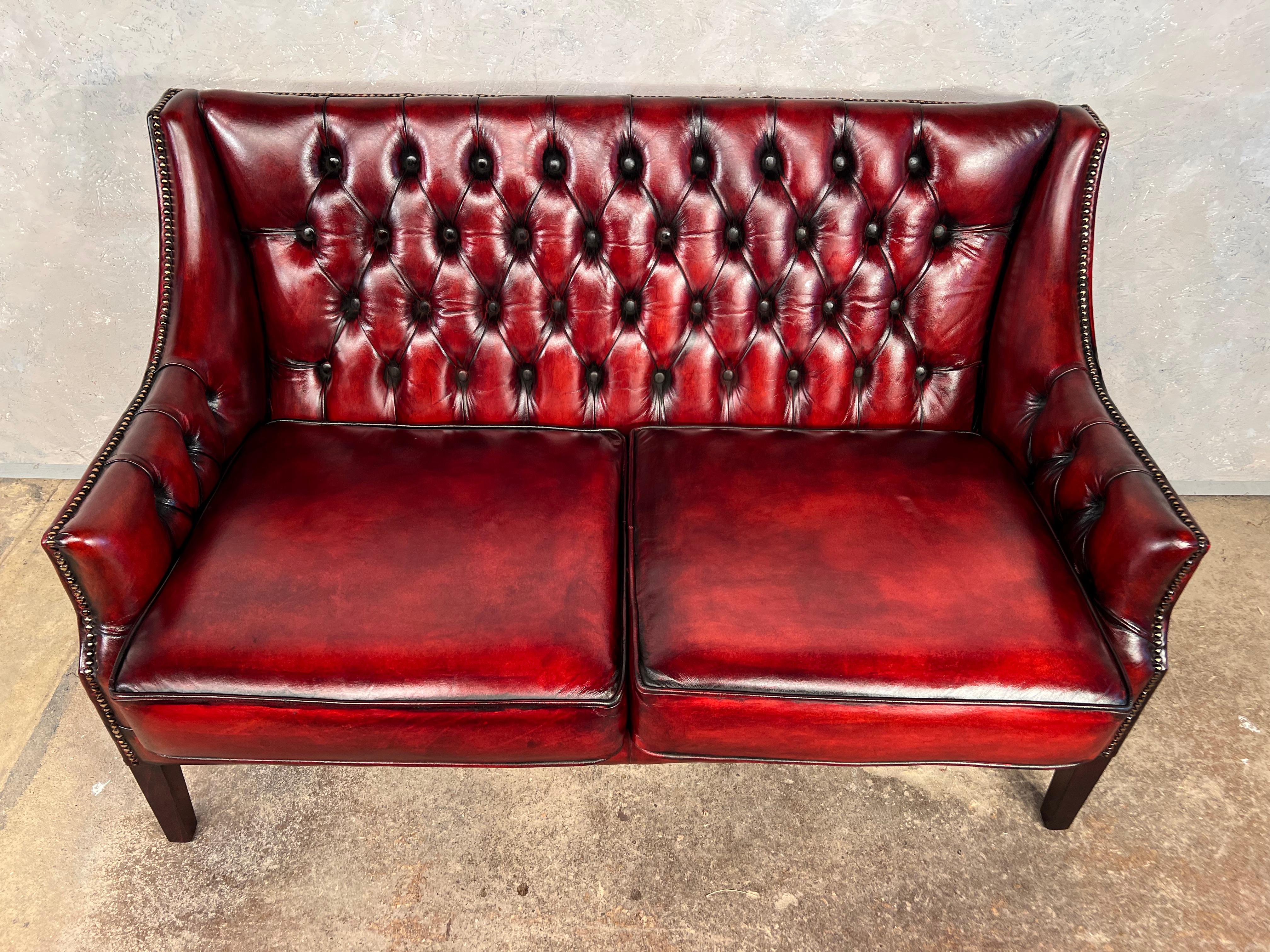 Un Chesterfield en cuir de grande qualité du milieu du siècle, belle taille soignée, il se tient magnifiquement sur les jambes effilées, cuir de grande qualité.

En excellente condition vintage, avec une belle. Finition rouge profond teintée à la