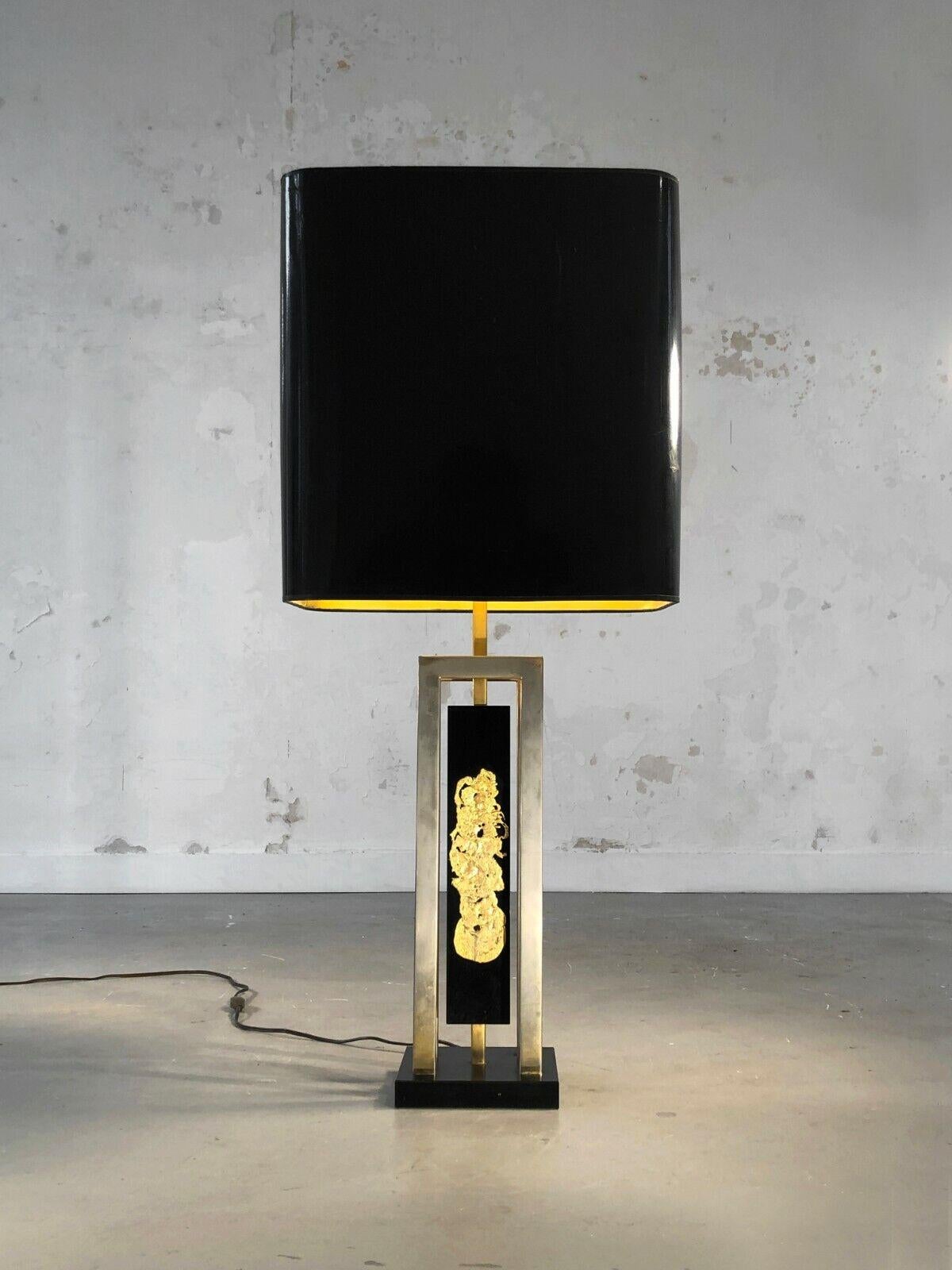 A spectacular table or floor lamp, Art-deco, Modernist, Neo-Classical, Neo-Baroque, black resin base topped with a geometric structure in gold metal decorated with a sculpture or compression of gold metal mounted on black plexiglass, the whole