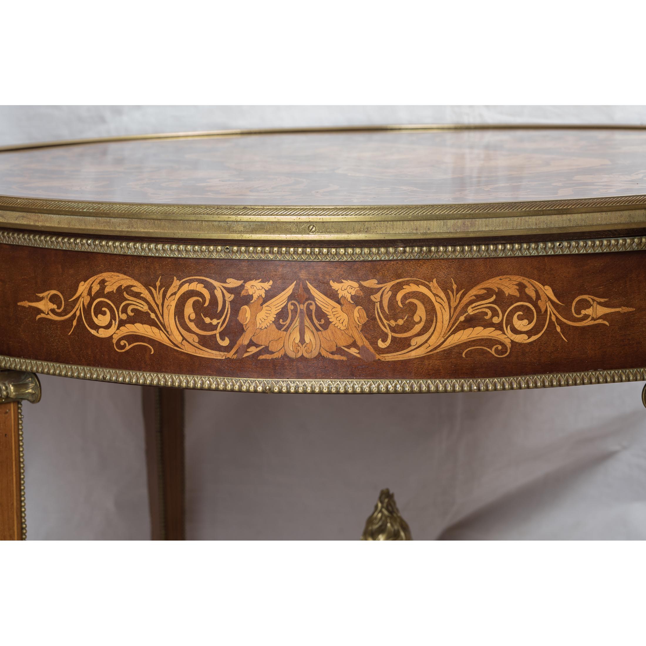 A fabulous neoclassical Ormolu-mounted parquetry and satinwood marquetry center table. This fabulous table features beautiful marquetry decoration in kingwood with elegant ormolu borders. The central panel is beautifully inlaid with an elegant urn
