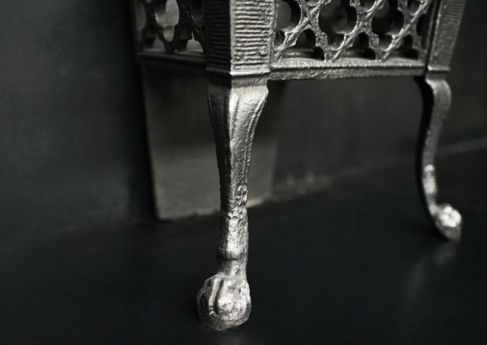 A delicate cast iron firegrate in the neo-Gothic taste. The shaped paw feet with four leaf clover motif above. The cast iron back plate with nicely cast rose and foliage decoration. English, circa 1900. 

Width At Front:	444 mm      	17 ½