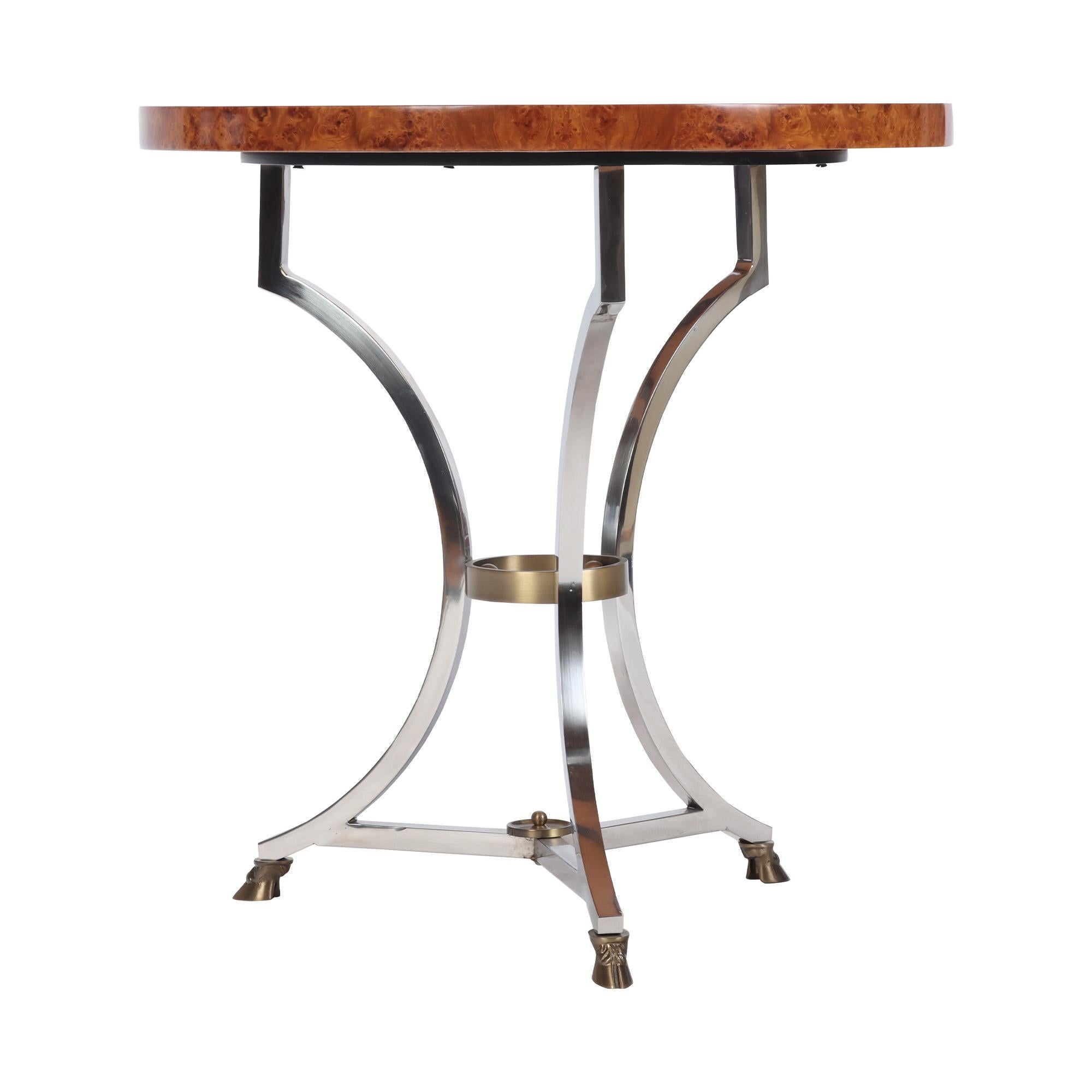 An elegant French Neoclassical inspired Gueridon or occasional table. Burl wood top with a brass and mix metal base. Circa 1950.