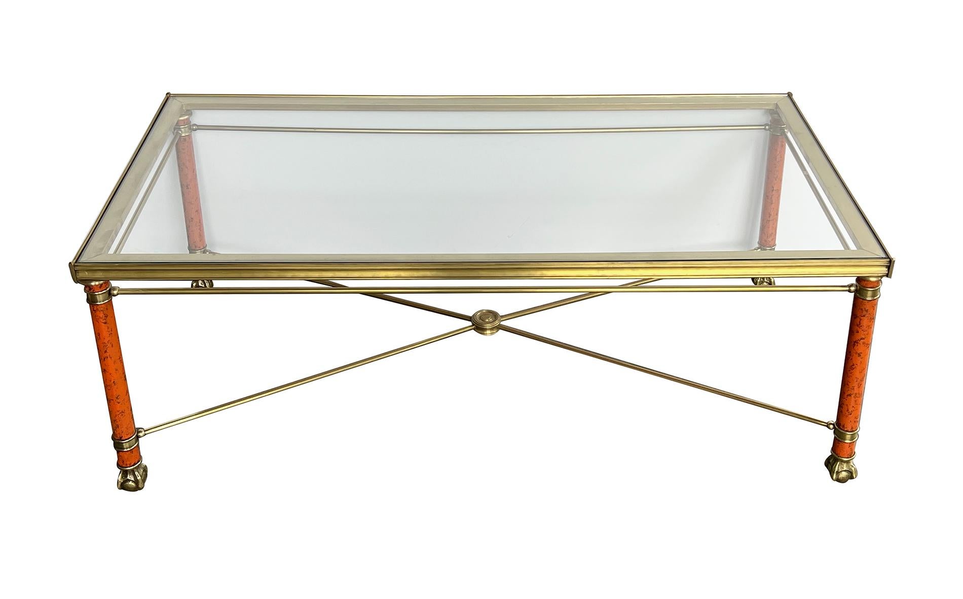 the inset glass top withing a bronze frame raised on cylindrical faux-marble metal supports ending in claw-and-ball feet all joined by an upper perimeter stretcher and lower x-form stretcher