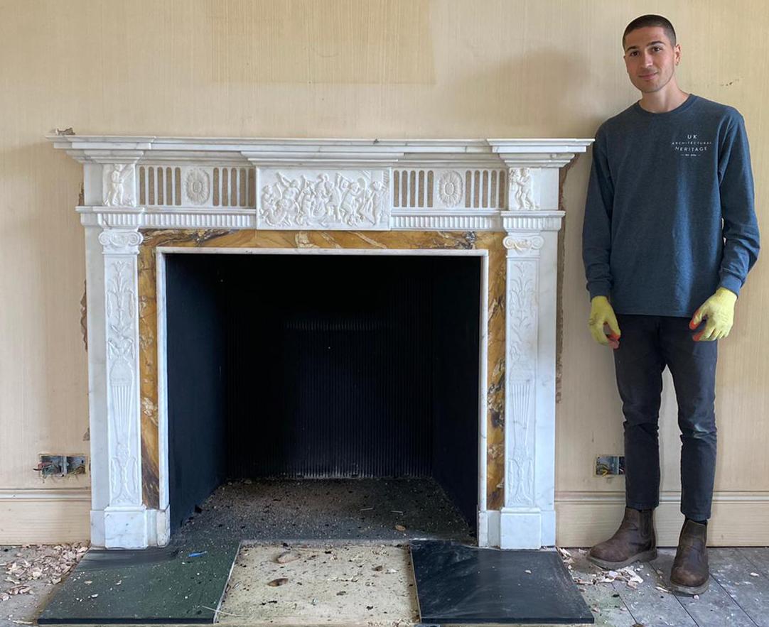 Antique neoclassical style carved marble fireplace. A late 19th century, neoclassical fireplace made from white statutory and Siena Marble. The central tablet of the frieze contains Putto’s with musical instruments in a beautifully detailed design.