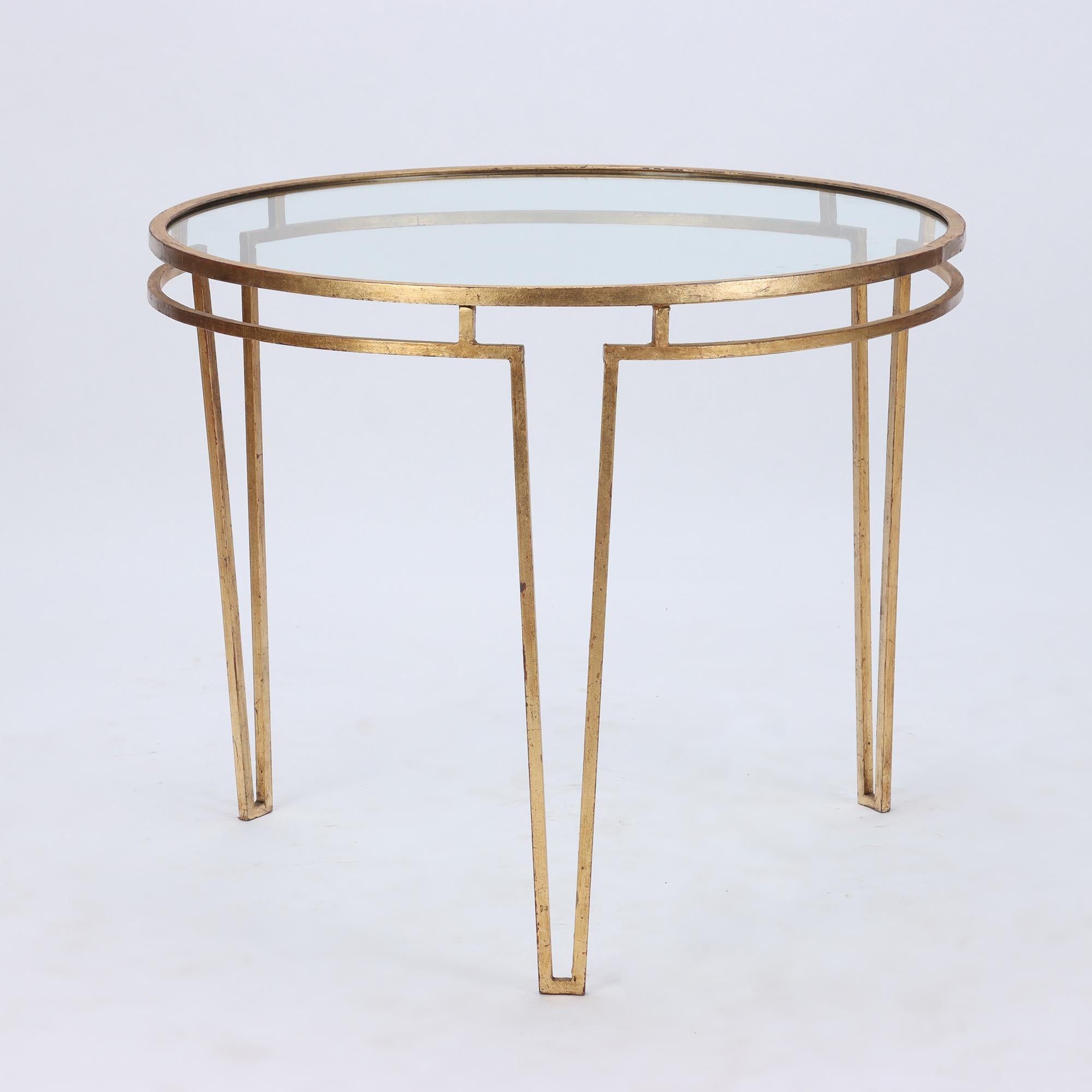 A beautiful Neoclassical gilt iron table with a glass top, in the manner of Jean Royere, C 1950.