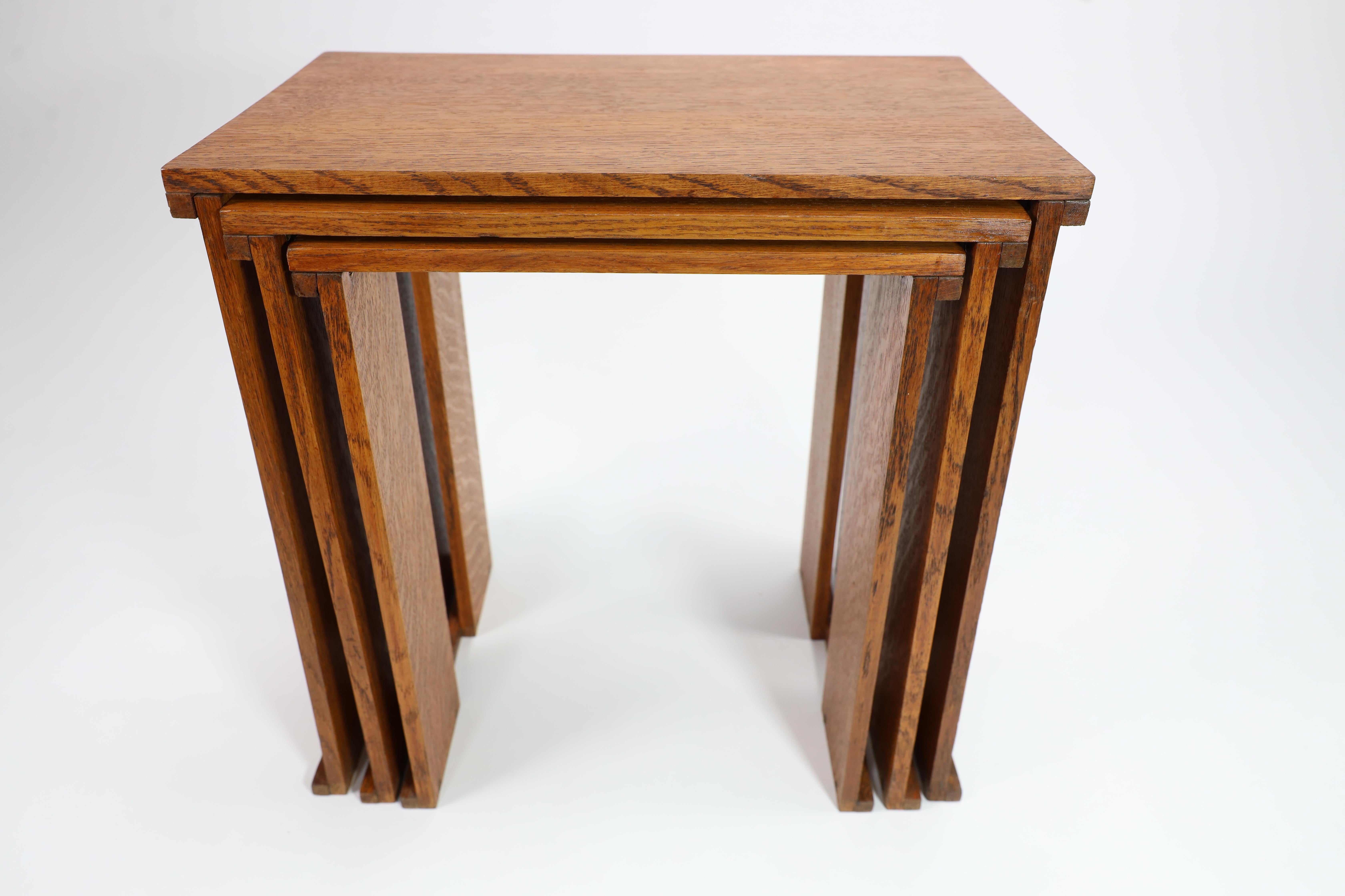 A nest of three Art Deco wild grain oak side tables of planked construction. 2