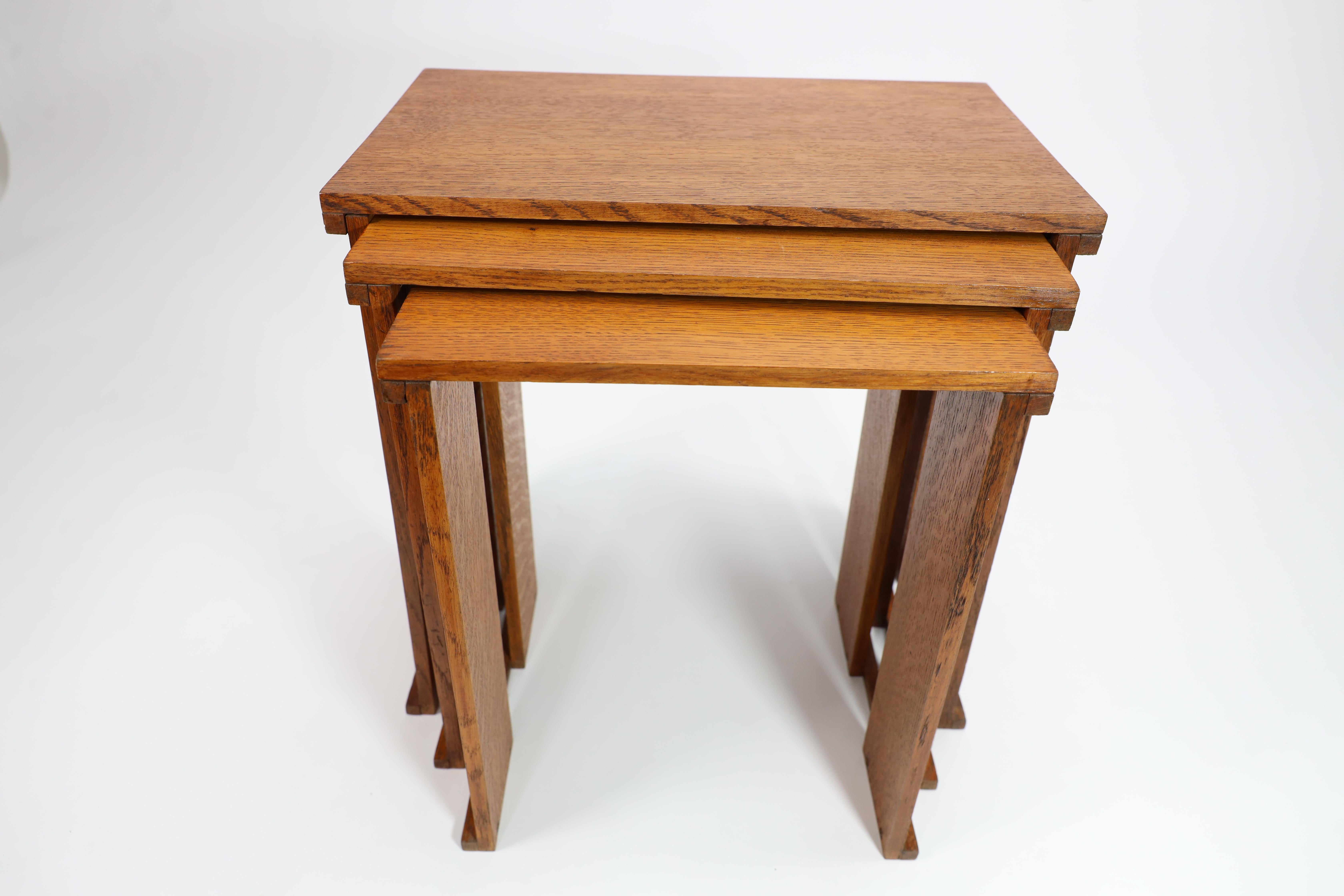 A nest of three Art Deco wild grain oak side tables of planked construction. 3
