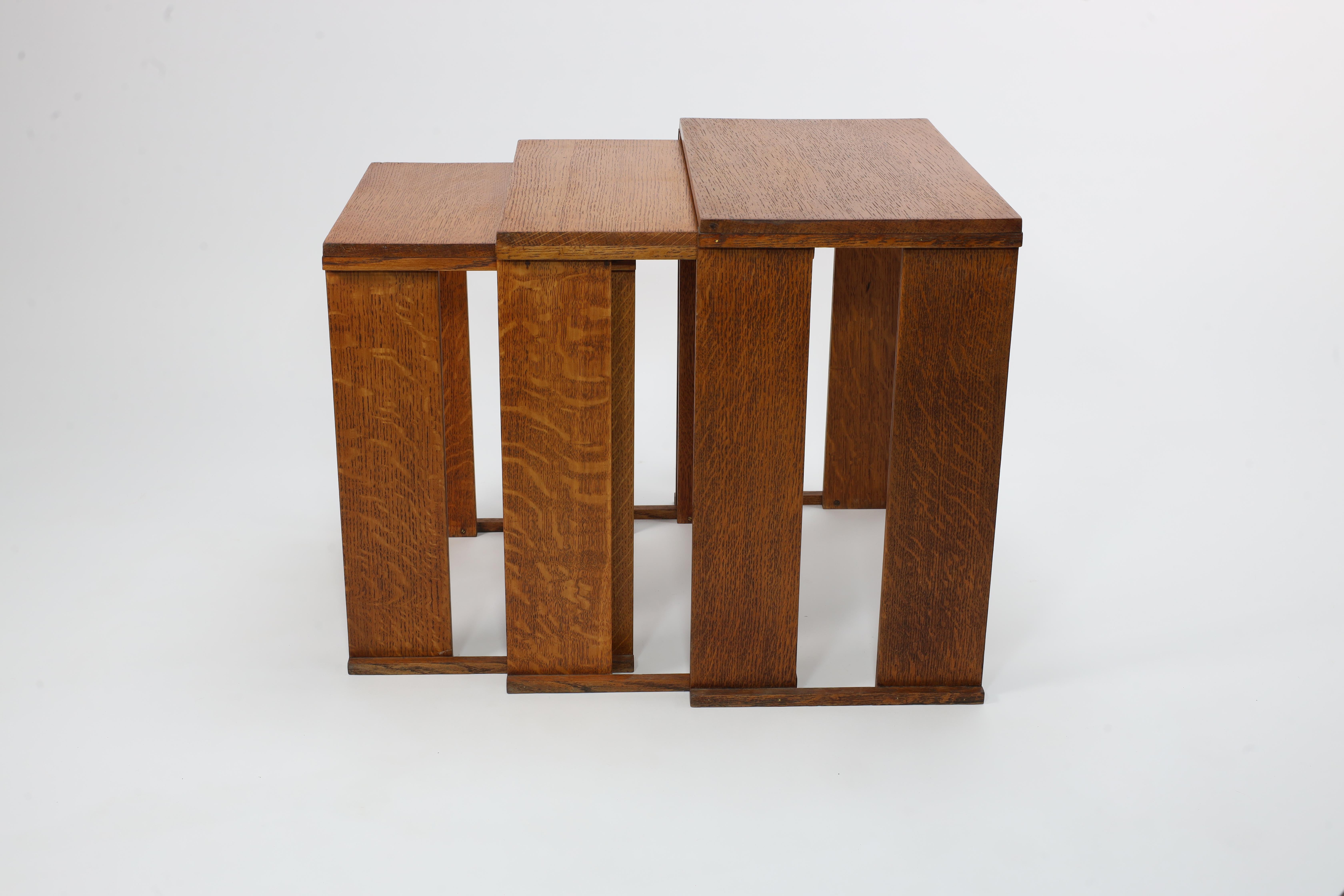 Early 20th Century A nest of three Art Deco wild grain oak side tables of planked construction.