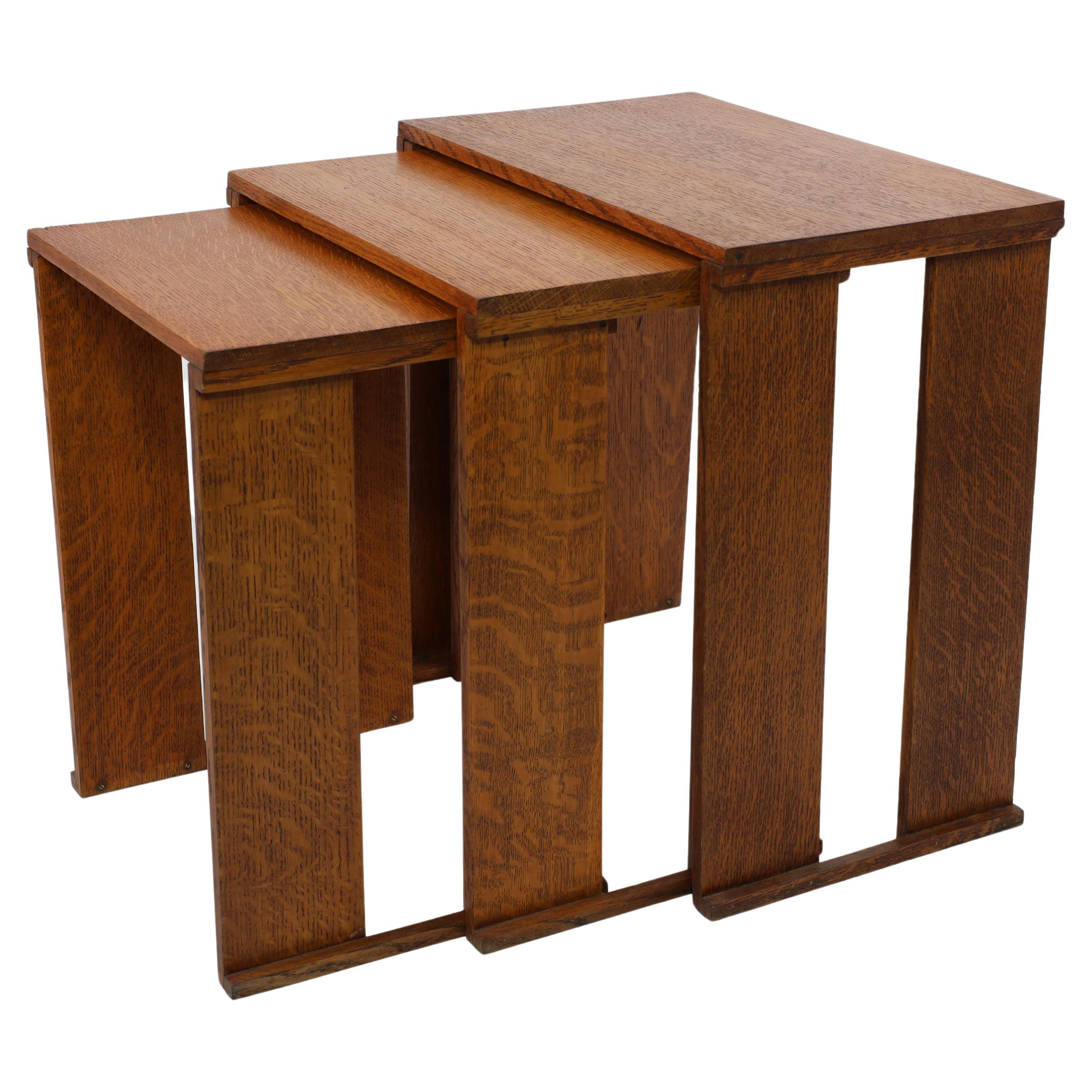 A nest of three Art Deco wild grain oak side tables of planked construction.
