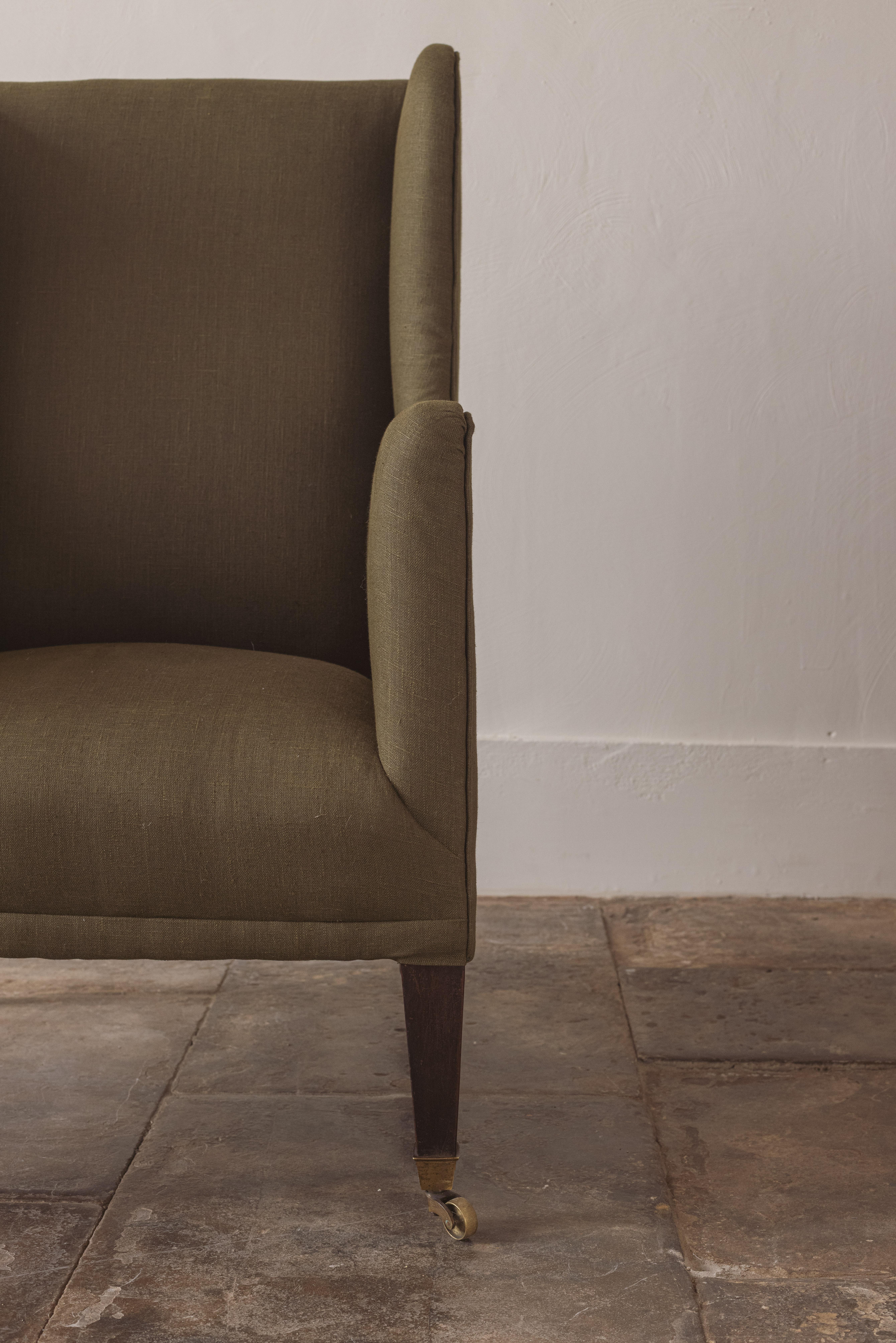 Una silla victoriana de respaldo alto especialmente elegante, con brazos gloriosamente estrechos. Retapizado en lino verde oscuro.