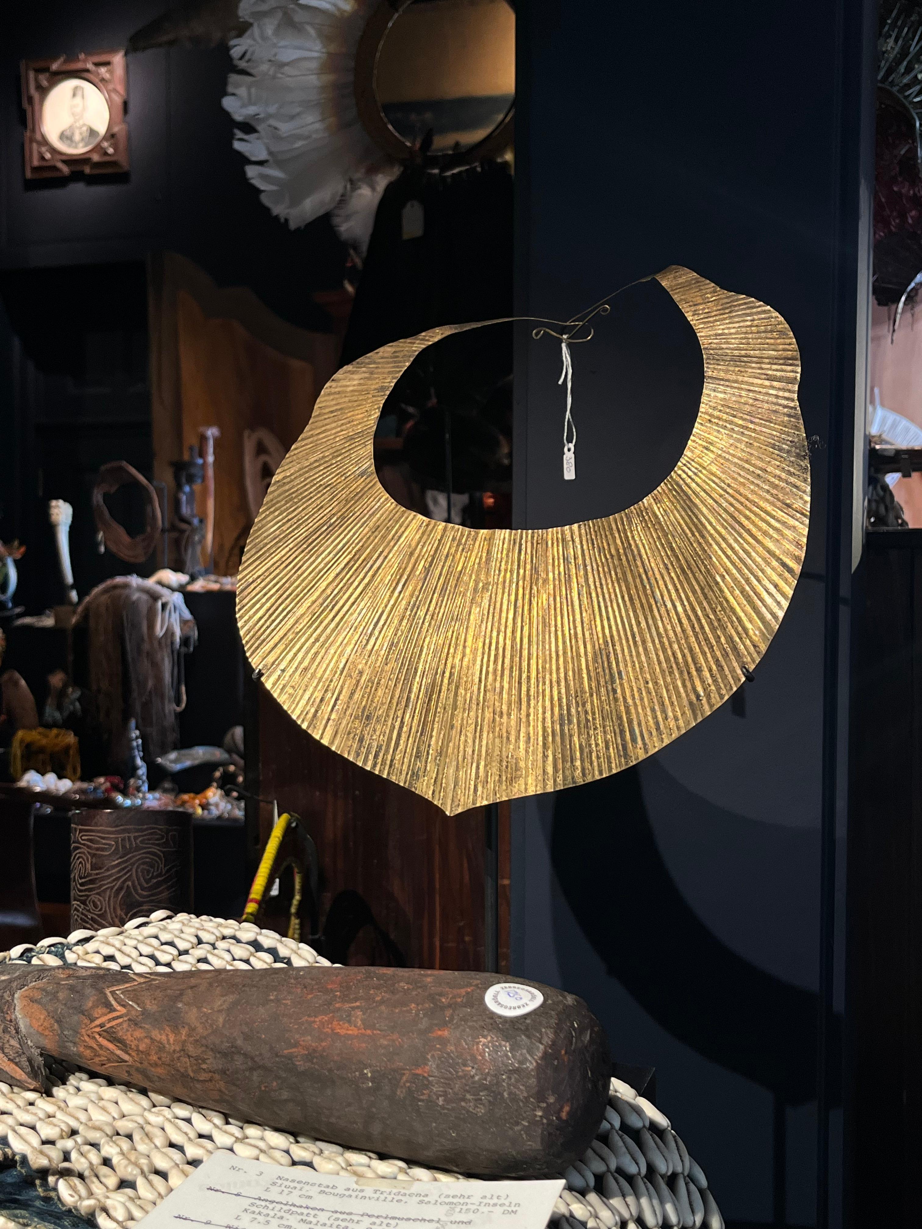 Indonesia, North Sumatra, Nias, 19th-20th century 

A crescent-shaped gold necklace hammered into folded ridges, the end fastened by interlocking hooks.

Diam. 27 cm

Provenance:
Collection Rinck Hollnberger, Munich

The nifato-fato is central to