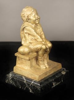 Bella scultura in bronzo dorato di un bambino seduto su una base di marmo di Juan Clara