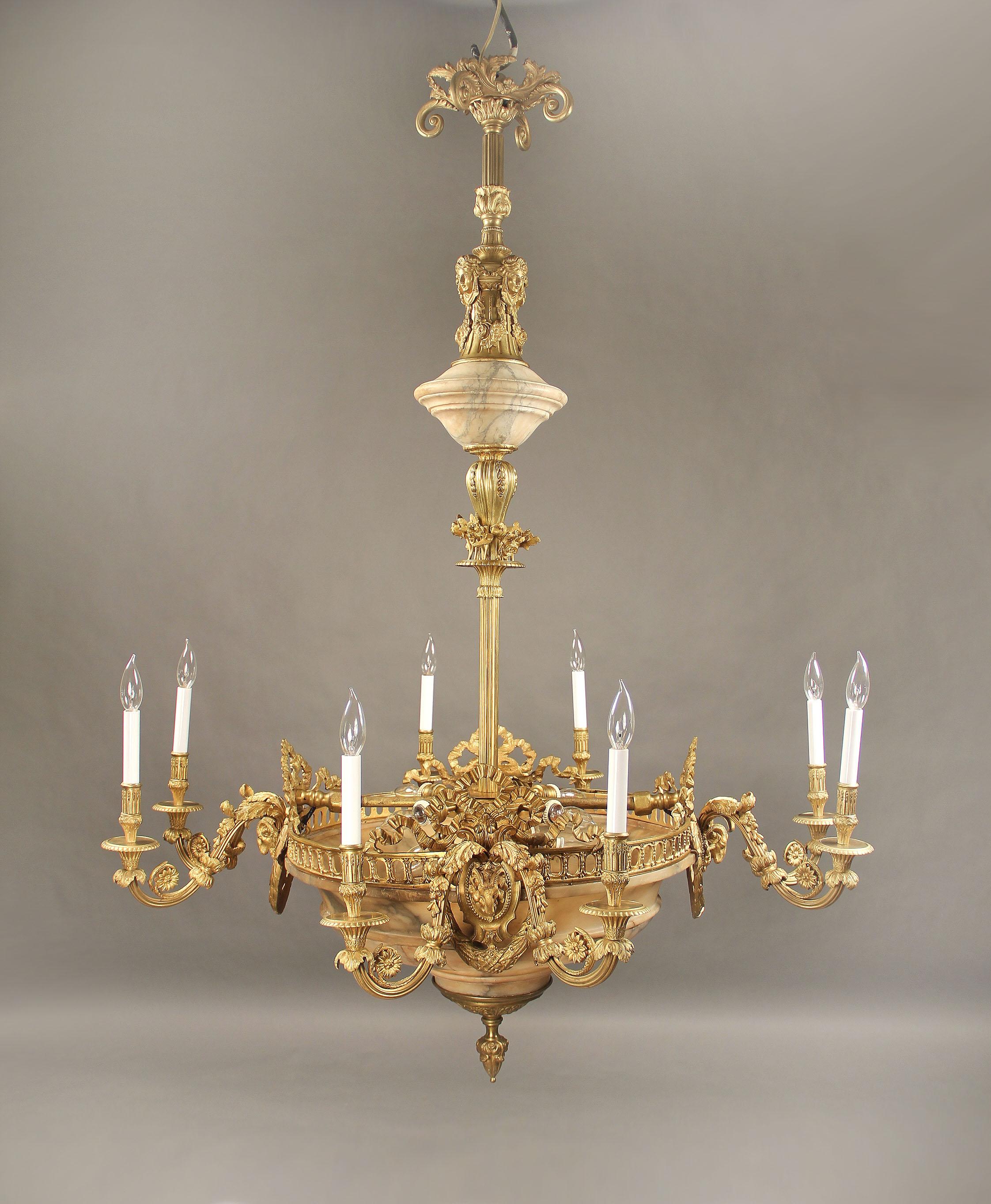 A Nice Late 19th Century Gilt Bronze and Alabaster 16 Light Chandelier

Bronze casted with an alabaster bowl, each set of arms centered with a rams heads, flowers and bows. Bronze female masks along the top.  Eight perimeter and eight interior