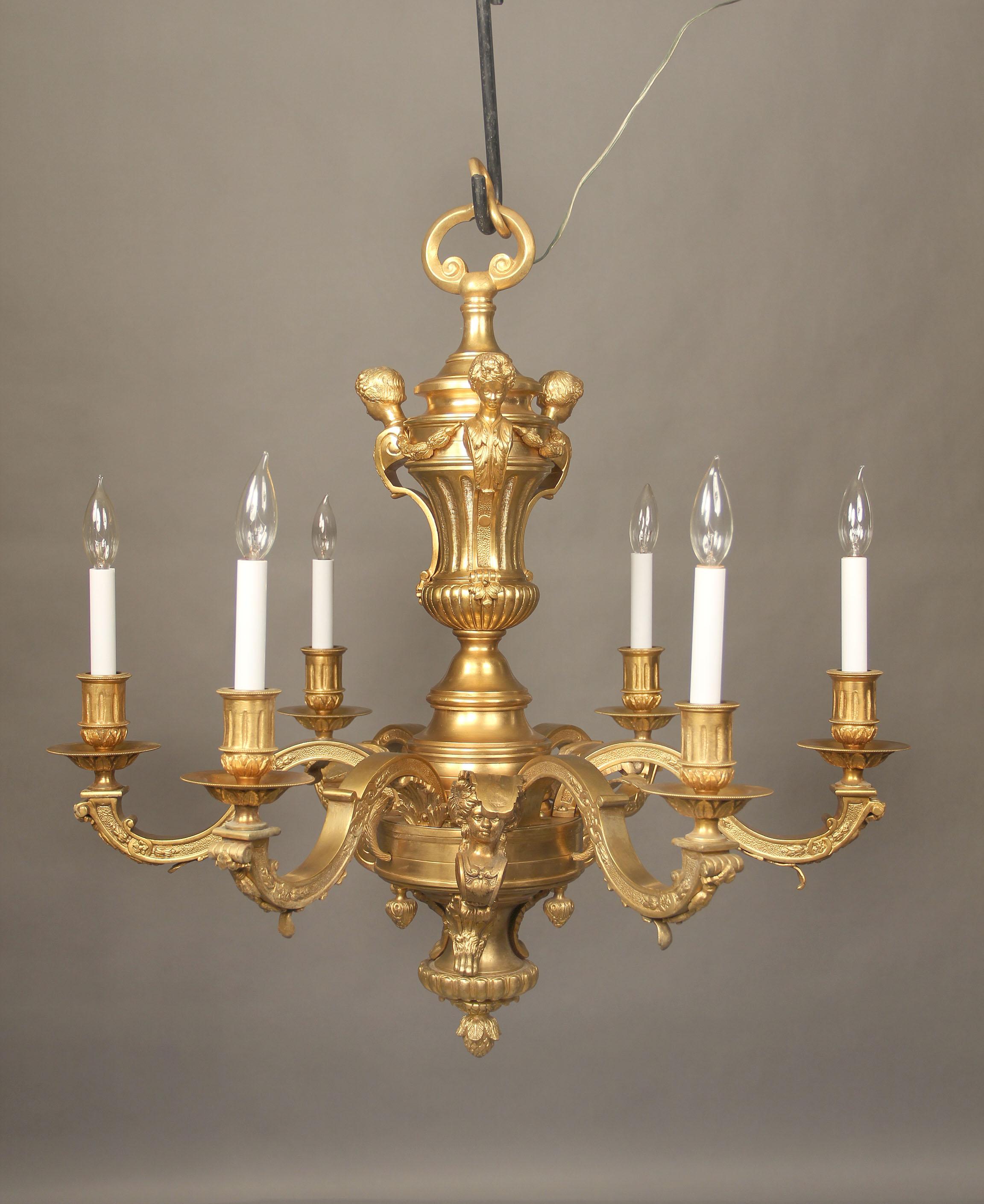 A nice late 19th century gilt bronze six light chandelier.

The bronze frame with women busts along the base and mens heads at the top, six perimeter lights.