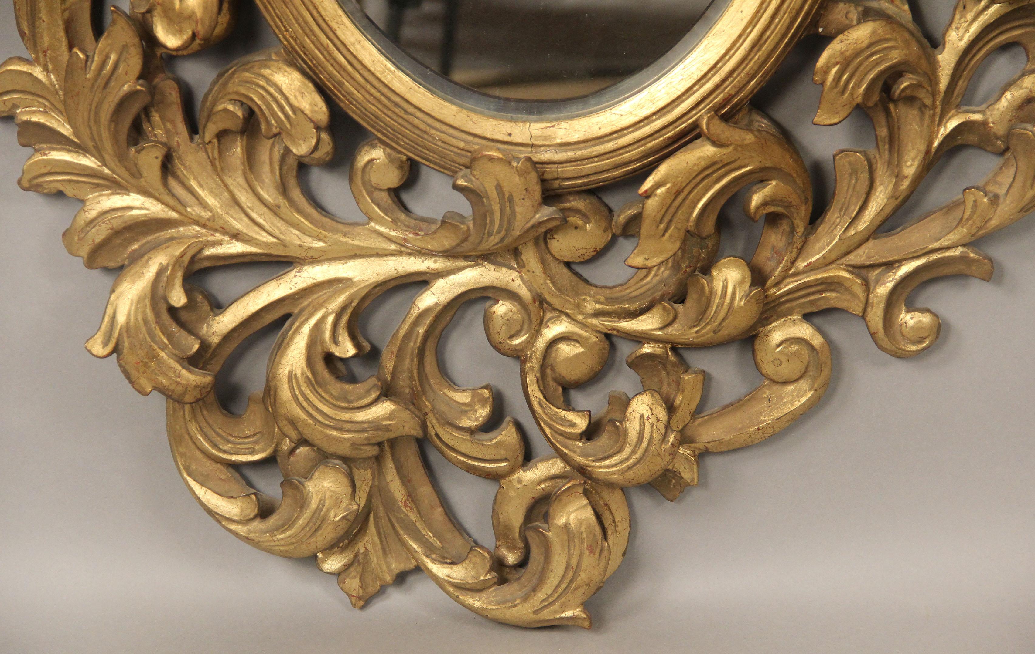 A Nice Late 19th Century Hand Carved Giltwood and Gesso Mirror

The mirror of oval and Rococo form.