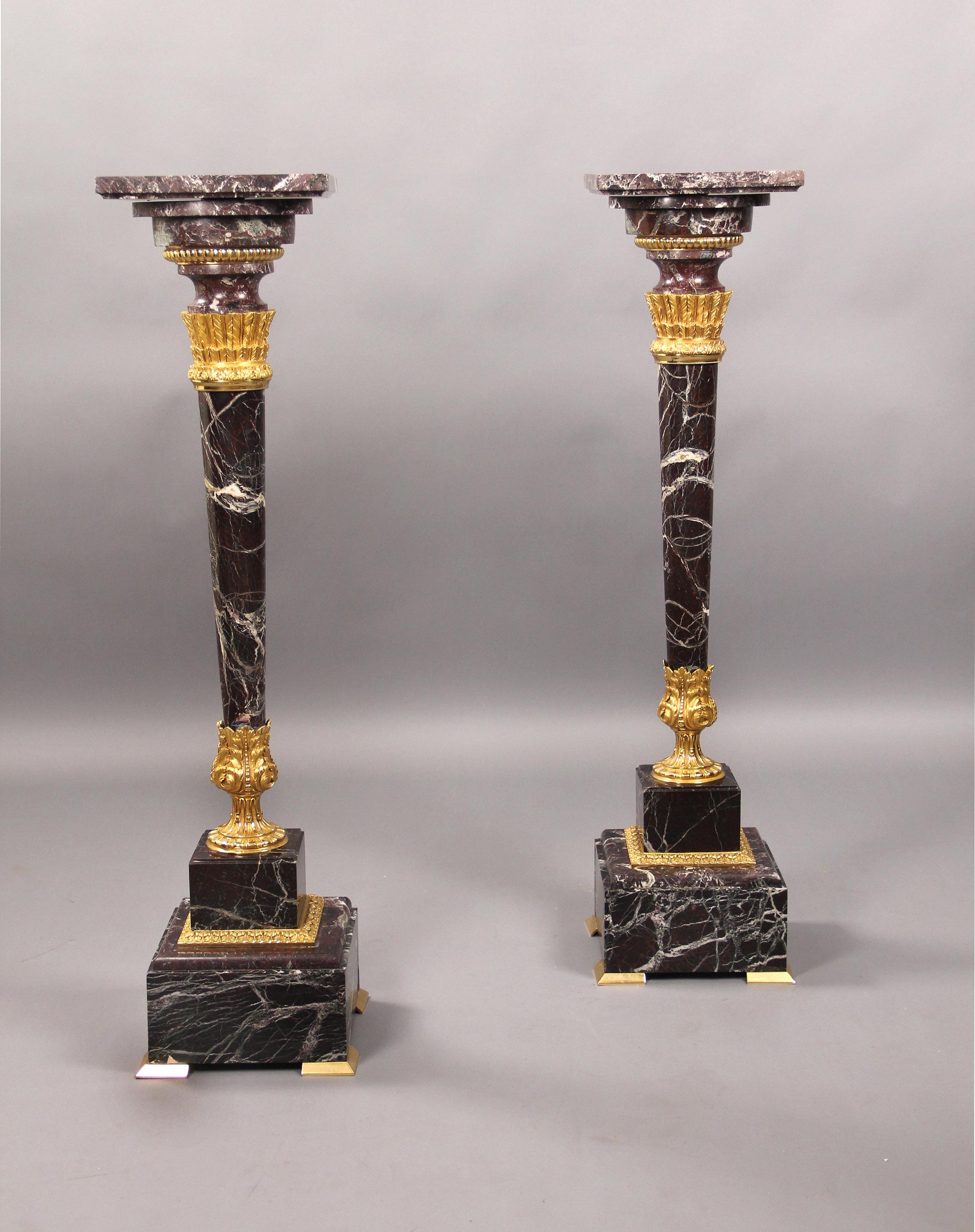 A Nice Pair of Late 19th Century Gilt Bronze Mounted Marble Pedestals

The square rouge marble top above a circular neck, the tapering columnar support mounted with gilt bronze arrow feathers and sitting in an bronze acanthus designed base, raised