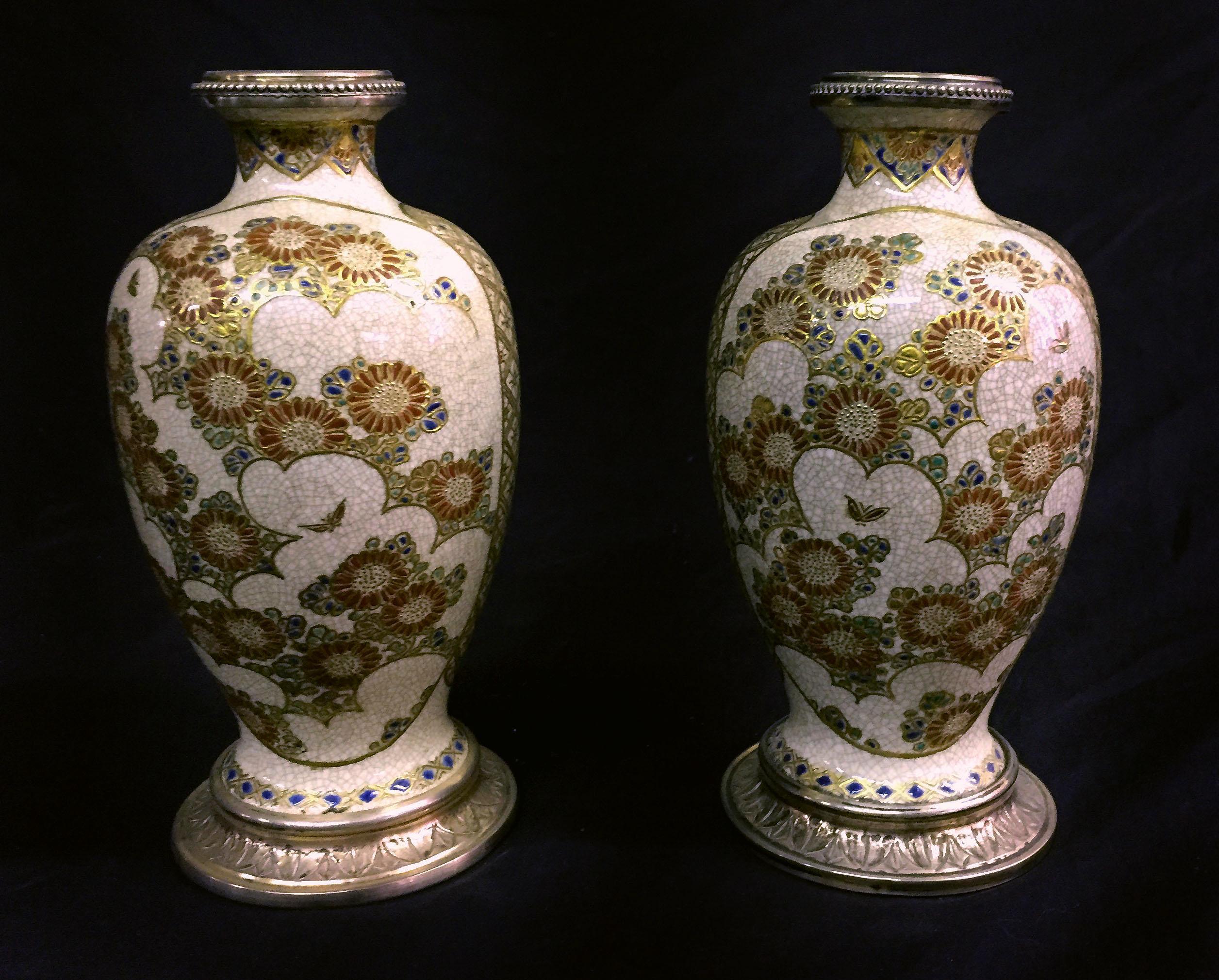 A nice pair of late 19th century silver mounted Japanese Satsuma porcelain vases.

The front panels painted with lion type figures, the back panels with flowers and butterflies, the entire vase with raised gold designs.