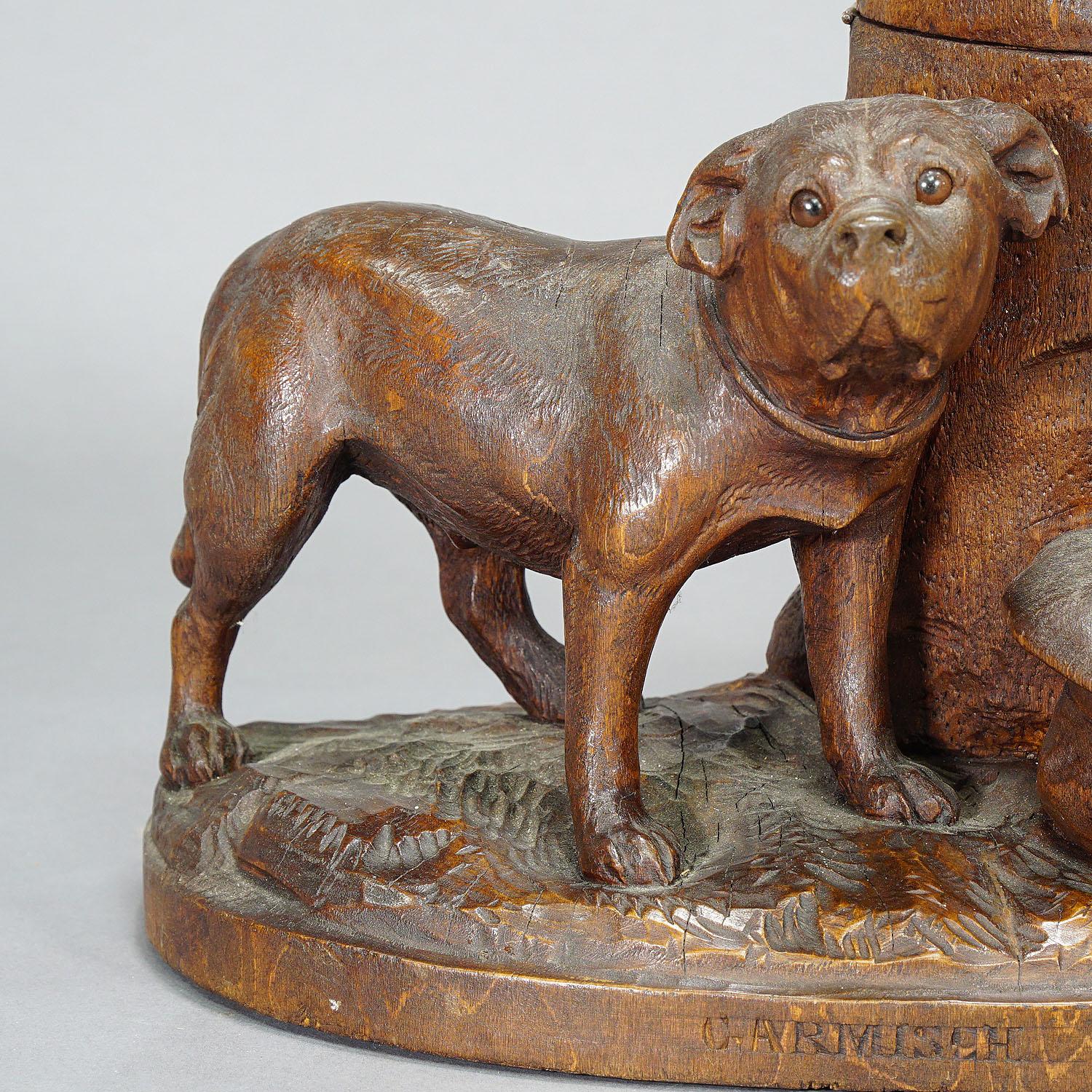 Wooden Carved Tobacco Box with Boxer, Switzerland ca. 1900

An early 20th century wooden carved humidor from Switzerland featuring a boxer dog beside a three trunk on witch the top can be flipped back to open the tobacco storage. In front of the