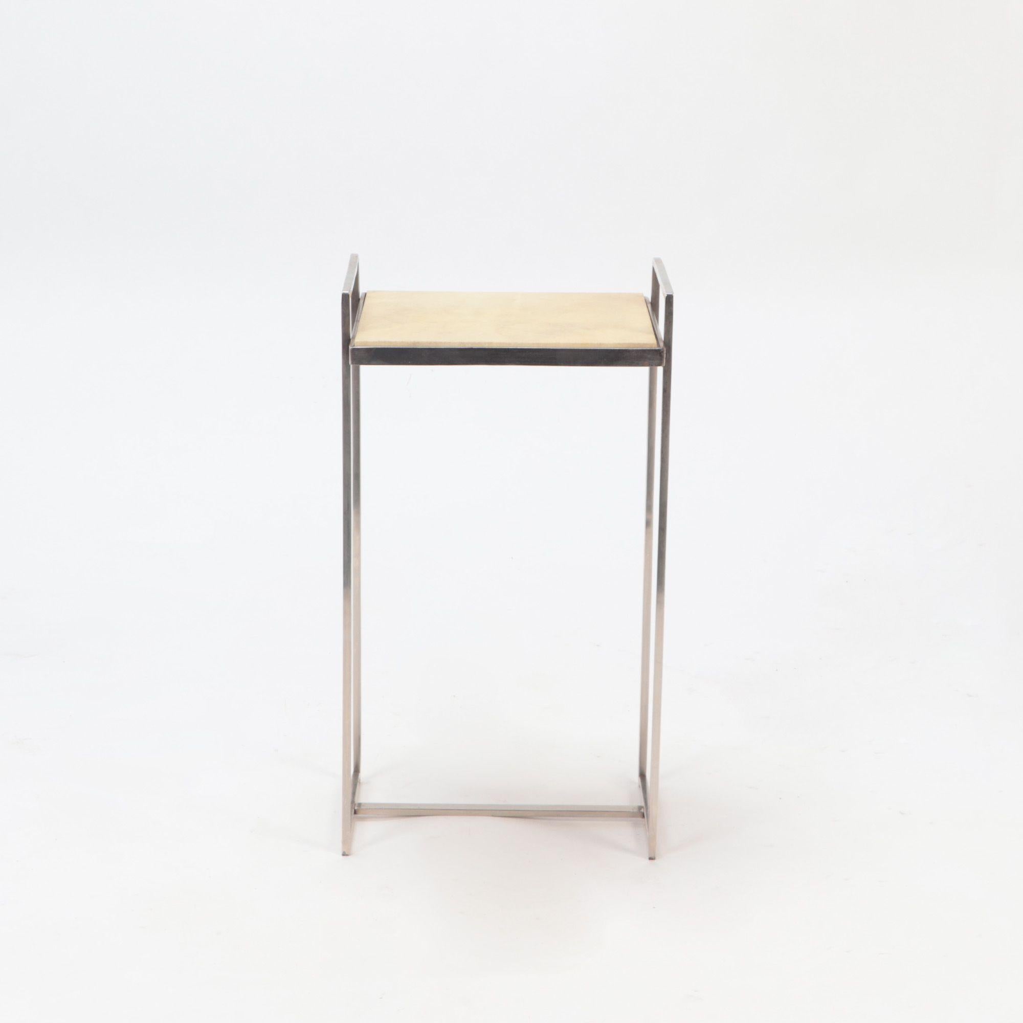 A nickel over iron drink table with parchment tops, contemporary.