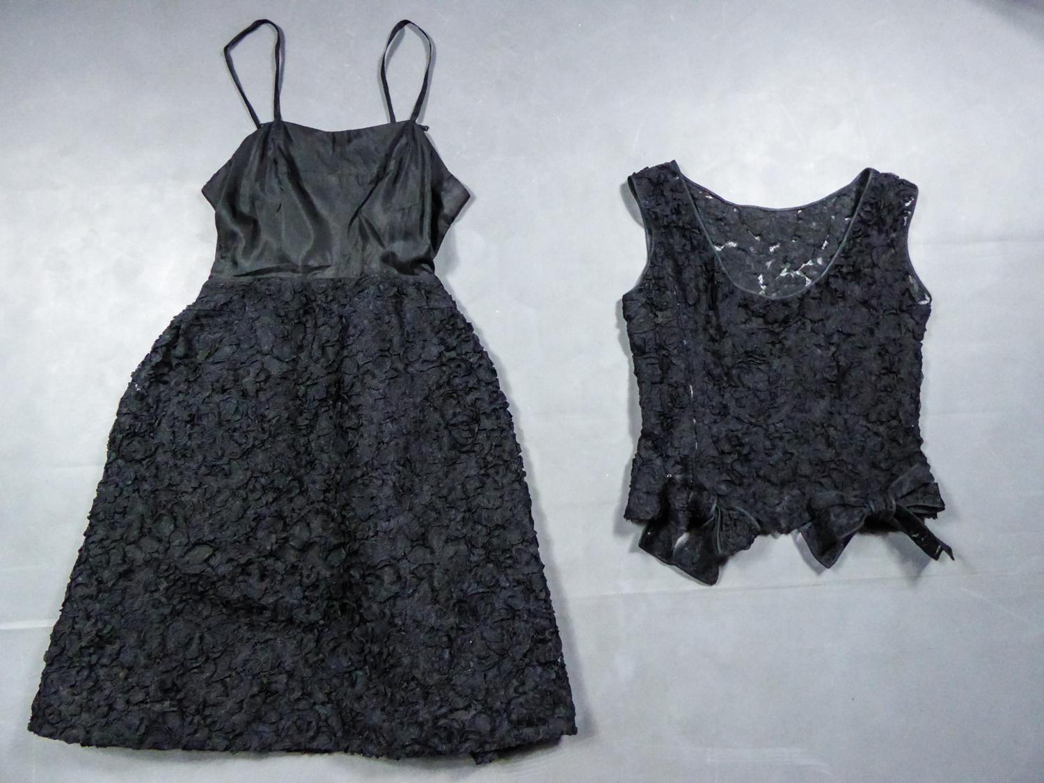 Circa 1960
France

A Nina Ricci Haute Couture little black evening dress in guipure lace embroidered with black laces from the 1960s. Dress composed of two parts: a sleeveless top with boat neckline and two knots on the kidneys. This top closing at