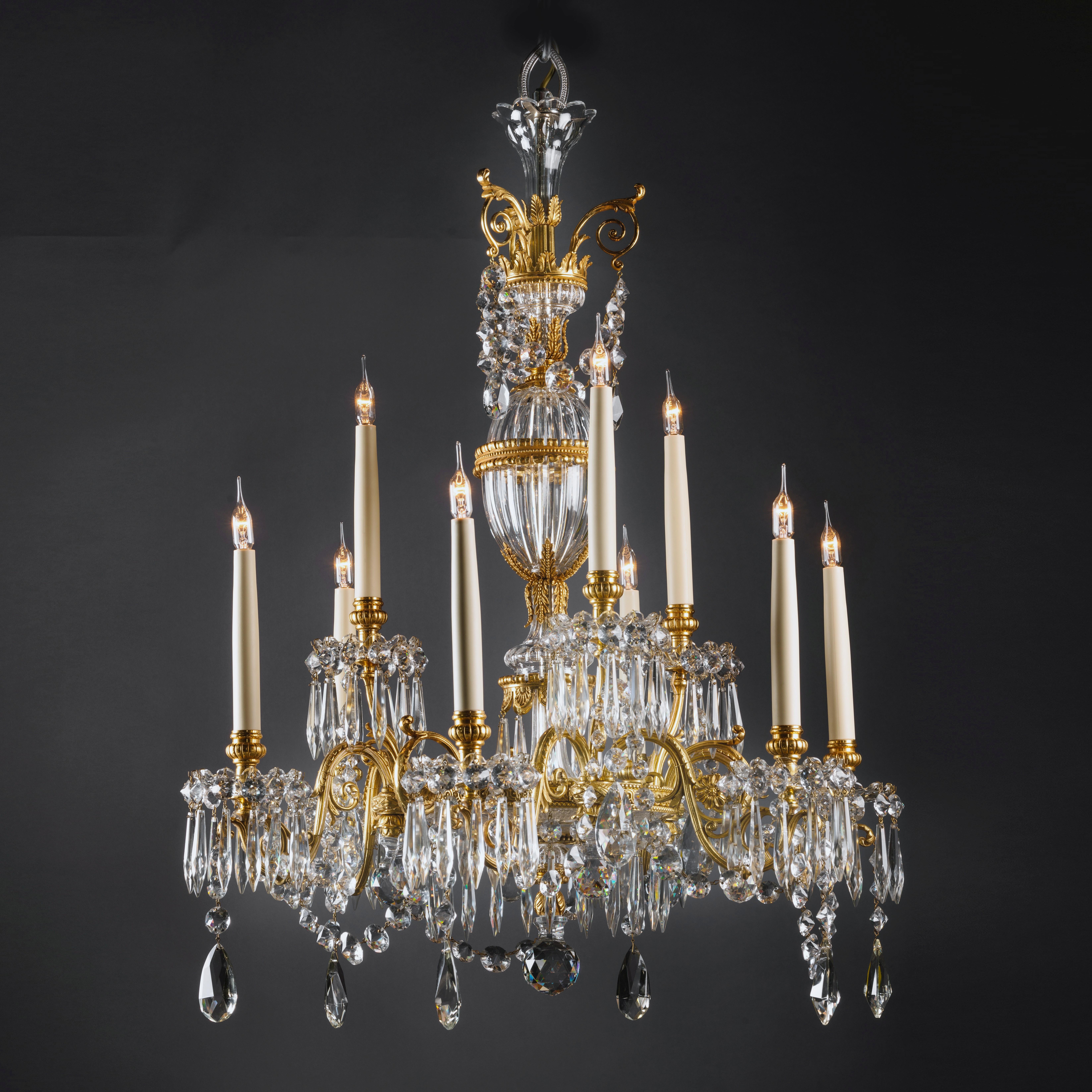 A fine gilt bronze, cut and moulded glass nine-light chandelier by Perry & Co.

This elegant English chandelier has a moulded glass ovoid and baluster stem with gilt bronze circlet, surmounted by a scrolling gilt bronze acanthus corona, above a
